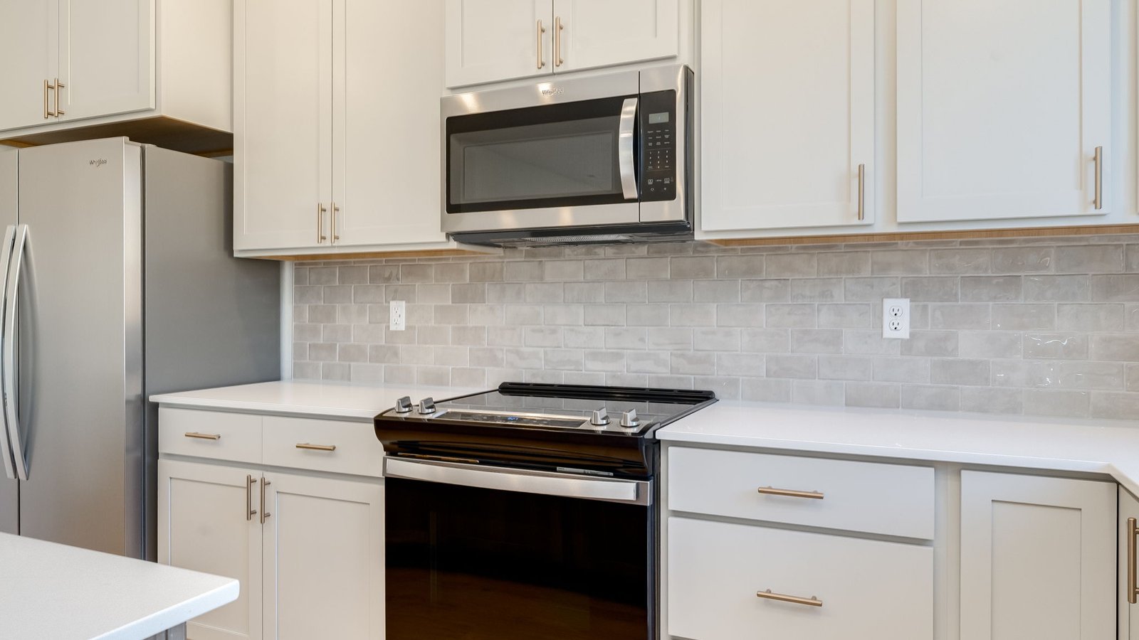 Kitchen with shaker cabinets, quartz counters, stainless steel appliances, pantry, and an island with a breakfast bar