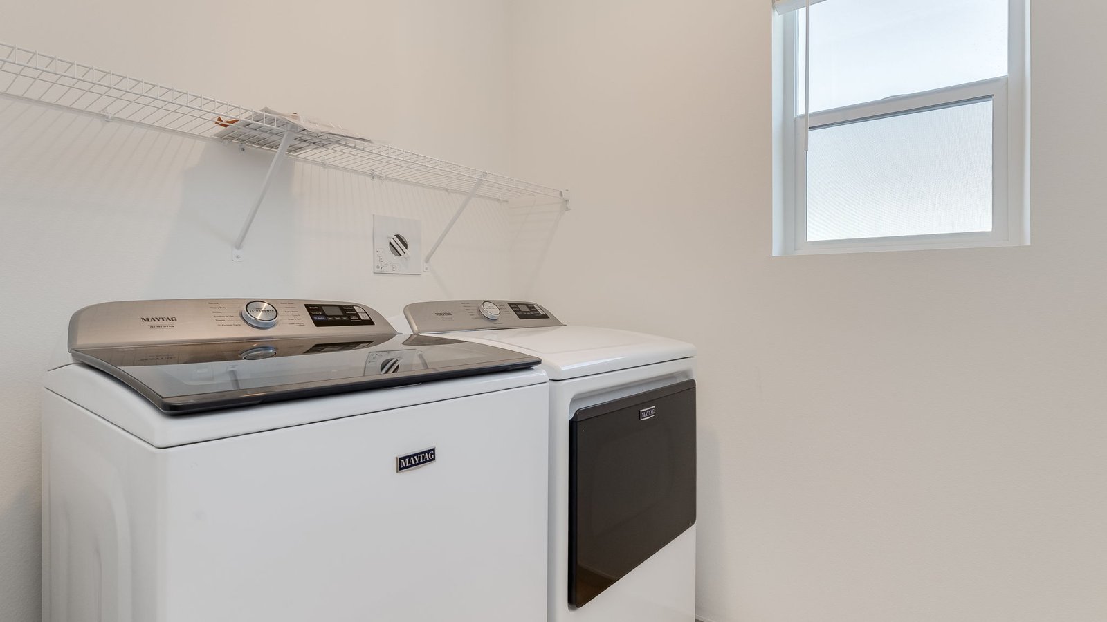 Laundry closet with wire shelves and washer and dryer hookups