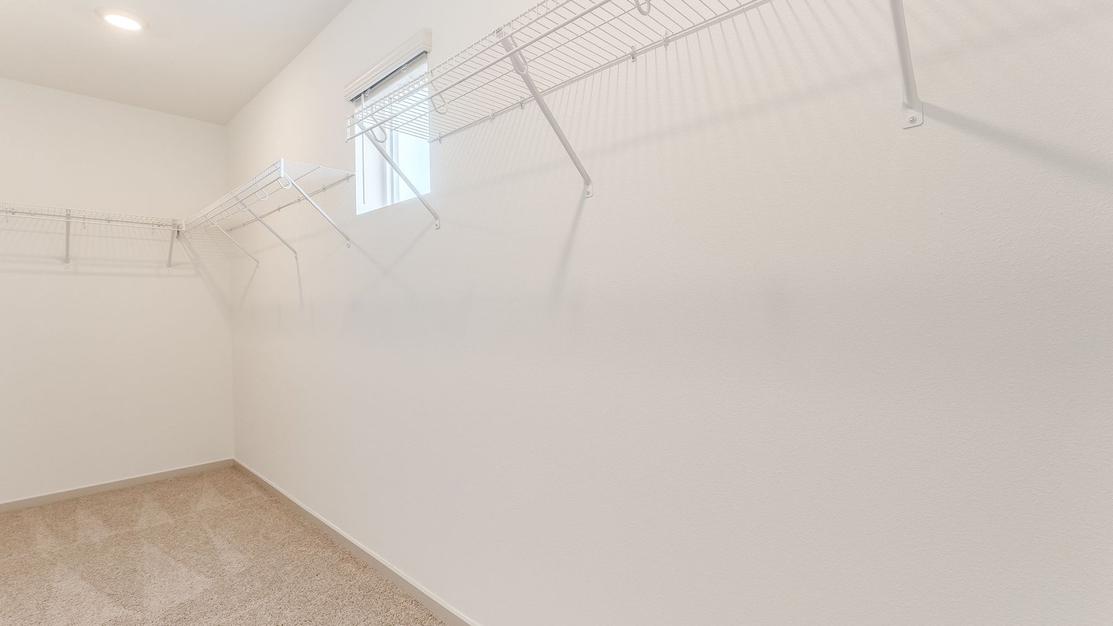Primary bedroom walk-in closet with wire shelves