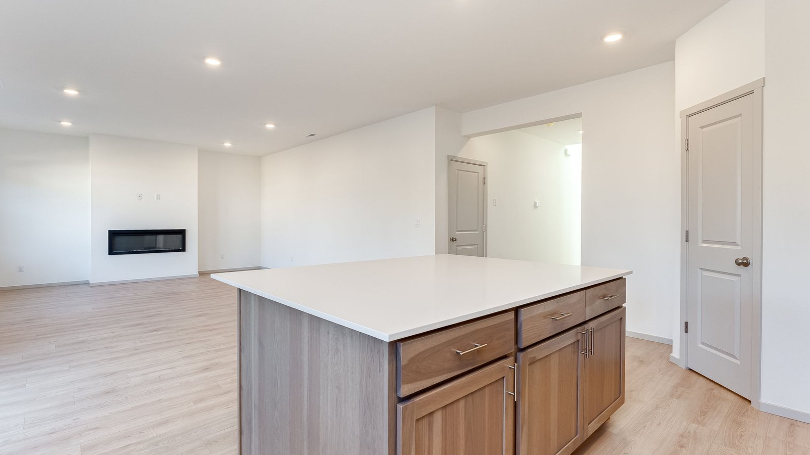Kitchen with shaker cabinets, quartz counters, stainless steel appliances, pantry, and an island with a breakfast bar