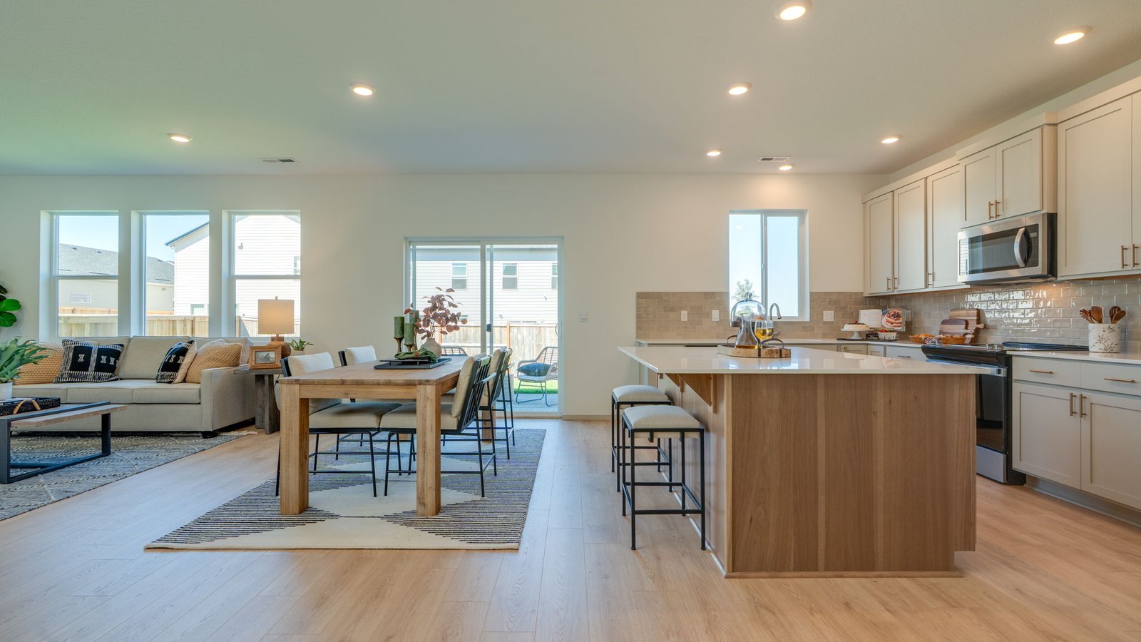 Kitchen with shaker cabinets, quartz counters, stainless steel appliances, pantry, and an island with a breakfast bar