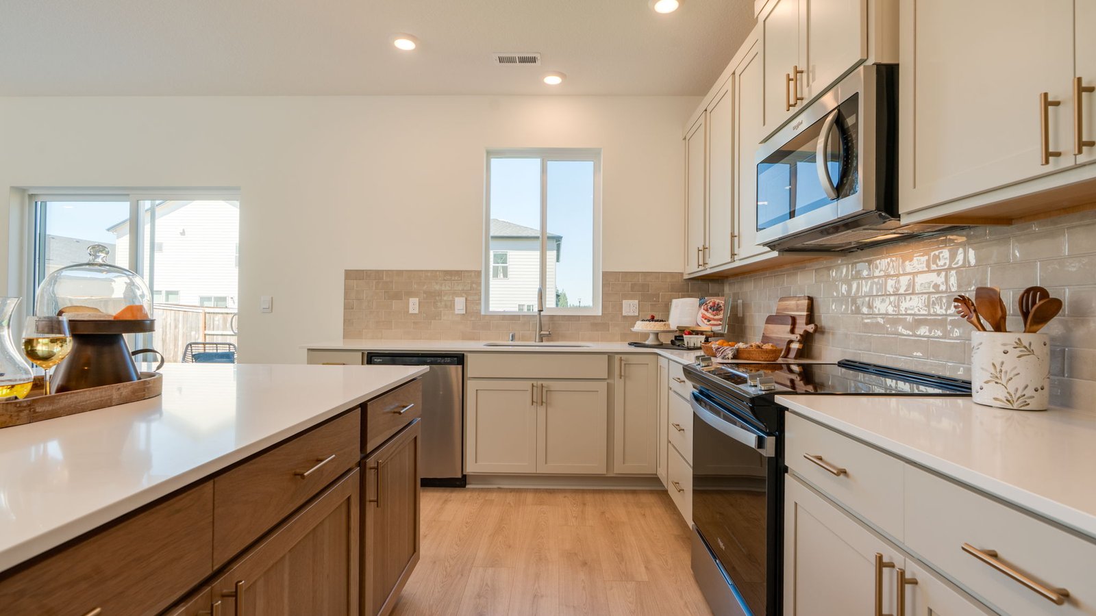 Kitchen with shaker cabinets, quartz counters, stainless steel appliances, pantry, and an island with a breakfast bar