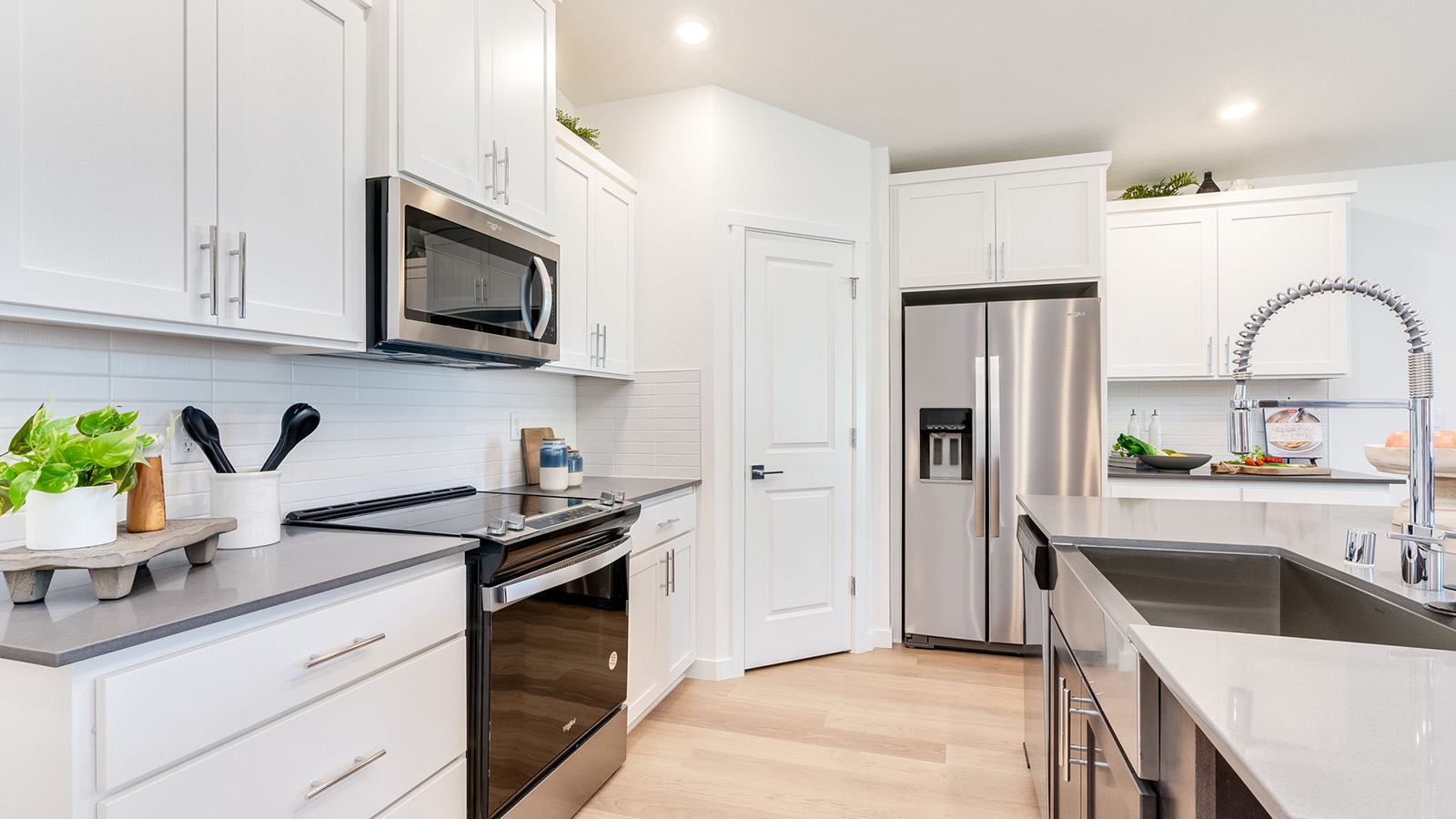 Kitchen with shaker cabinets, quartz counters, stainless steel appliances, pantry, and an island with a breakfast bar