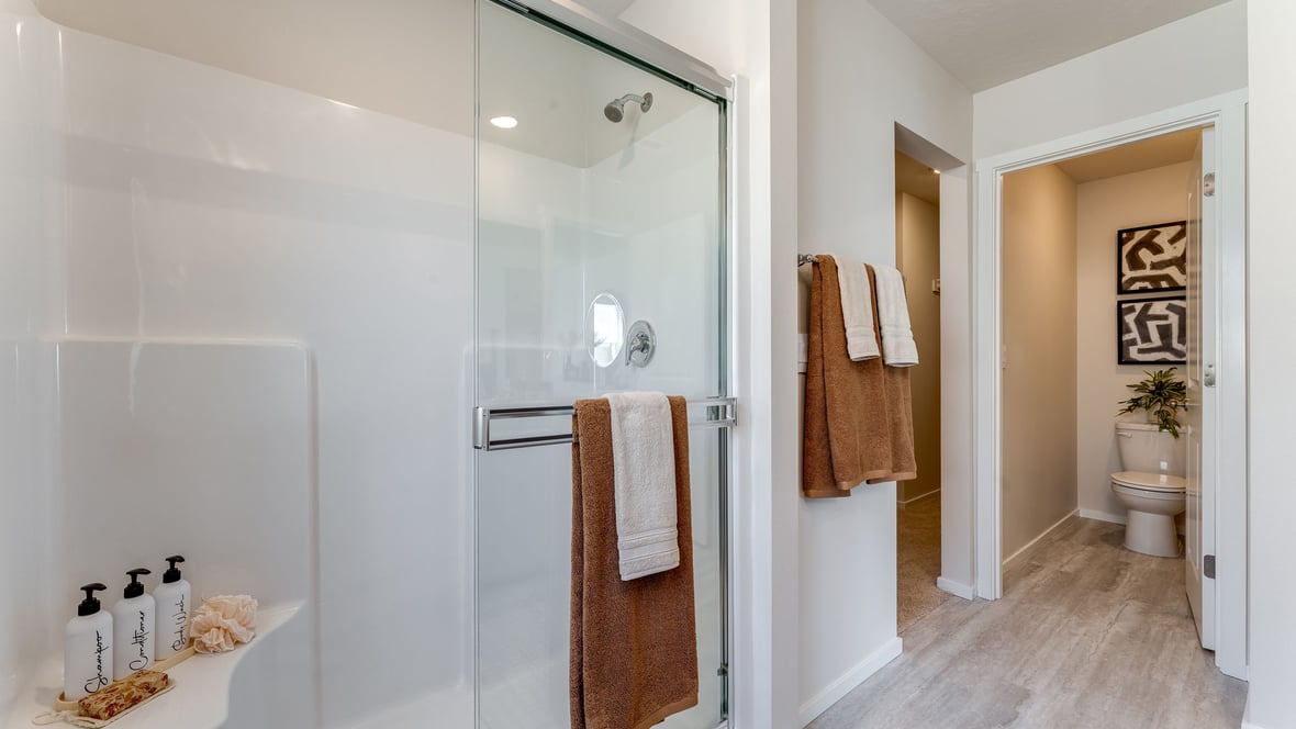 Primary bathroom with quartz counters and a walk-in shower