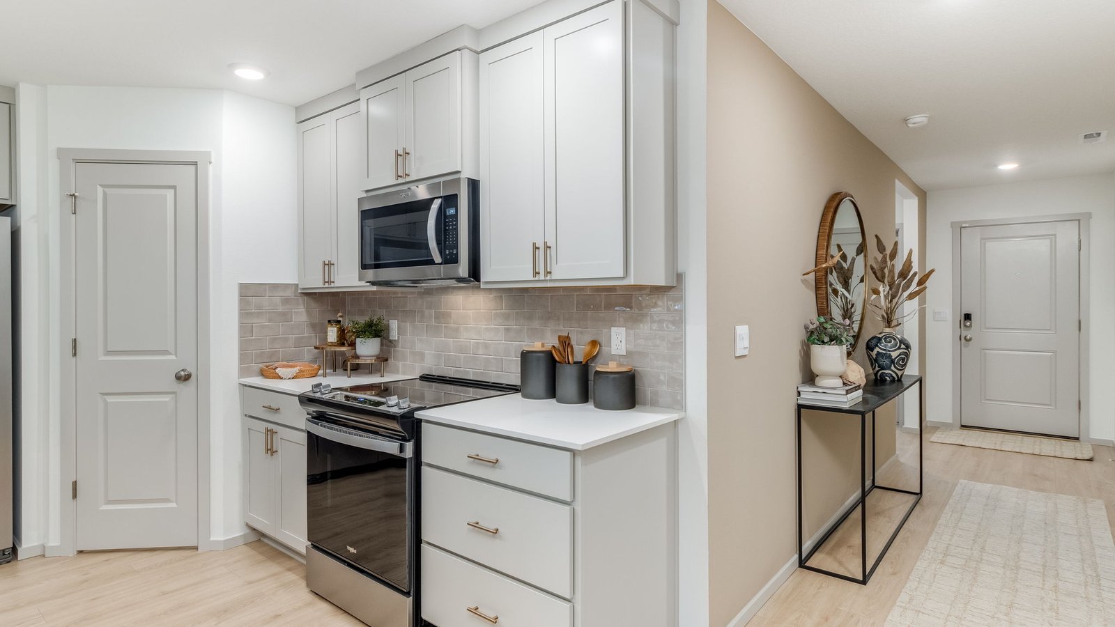 Kitchen with shaker cabinets, quartz counters, stainless steel appliances, pantry, and an island with a breakfast bar