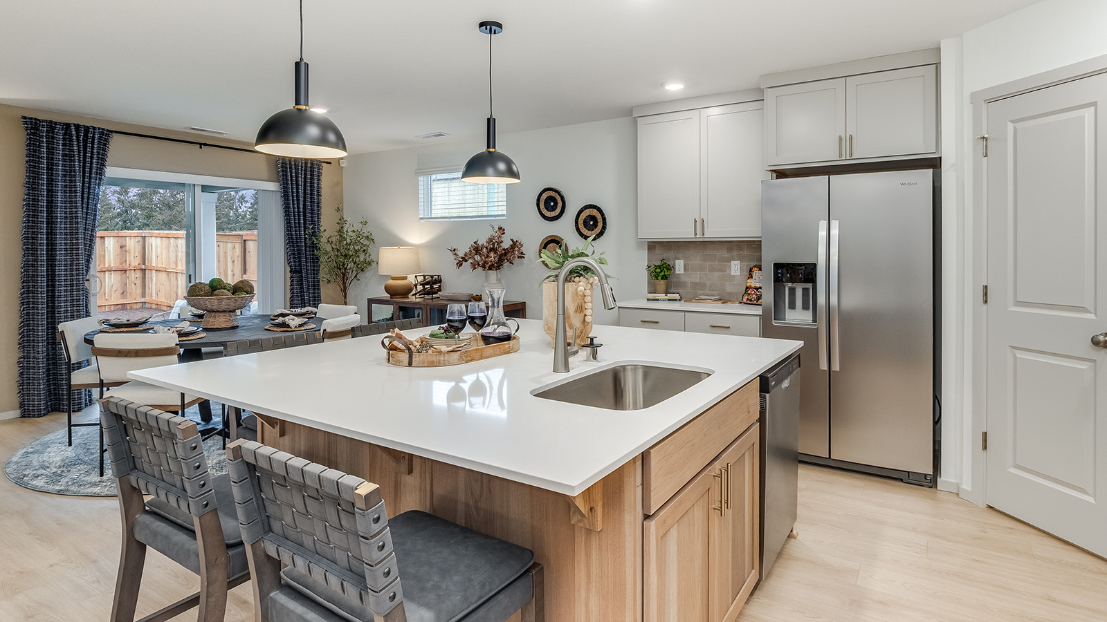 Kitchen with shaker cabinets, quartz counters, stainless steel appliances, pantry, and an island with a breakfast bar