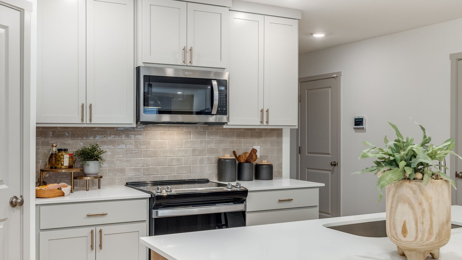 Kitchen with shaker cabinets, quartz counters, stainless steel appliances, pantry, and an island with a breakfast bar