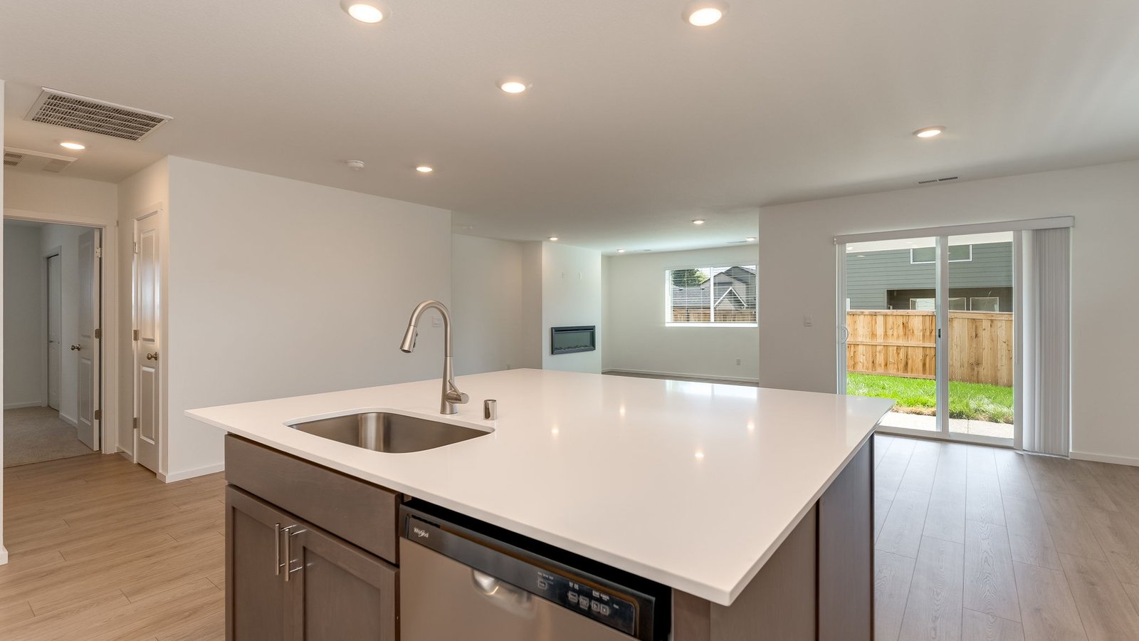 Kitchen with shaker cabinets, quartz counters, stainless steel appliances, pantry, and an island with a breakfast bar