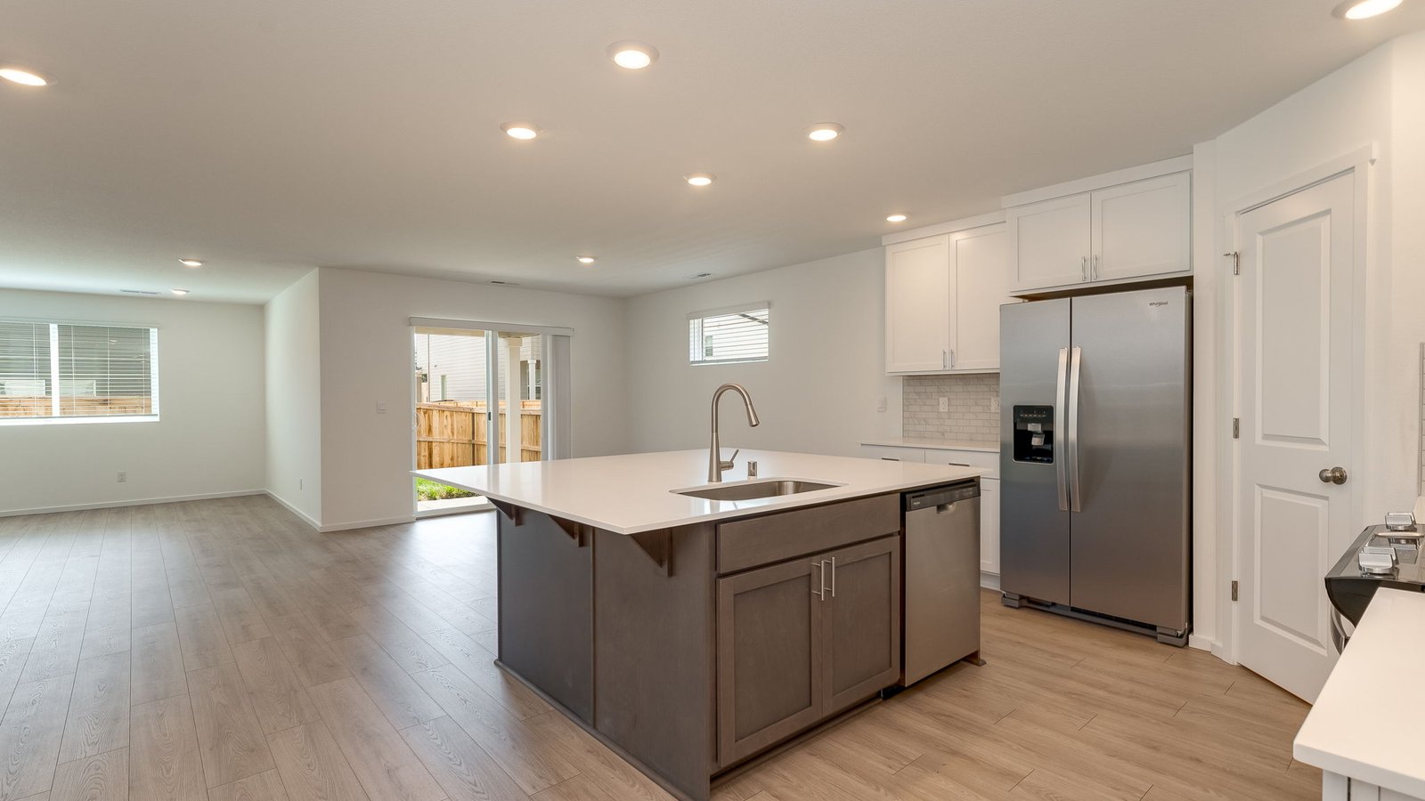 Kitchen with shaker cabinets, quartz counters, stainless steel appliances, pantry, and an island with a breakfast bar