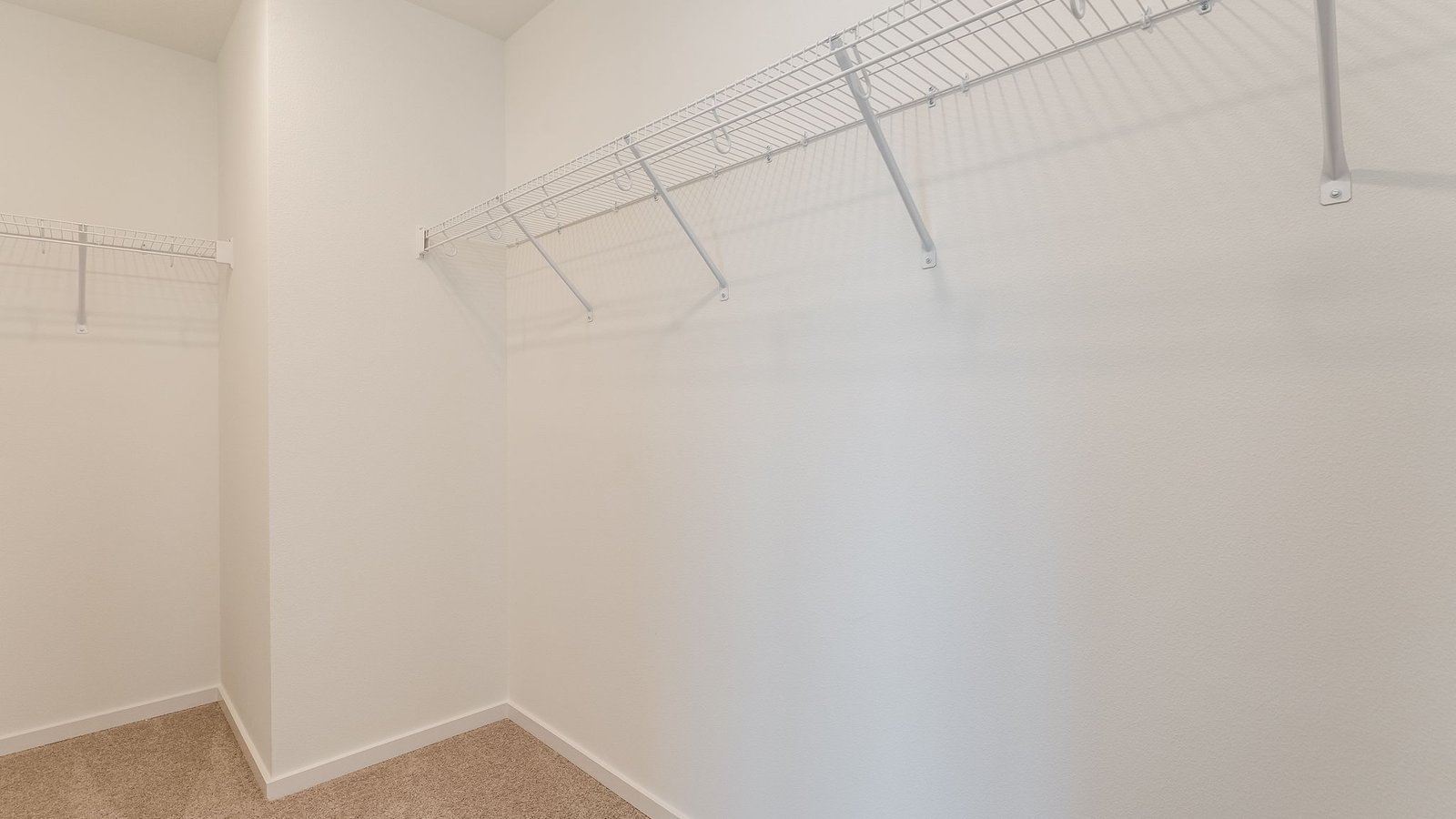 Primary bedroom walk-in closet with wire shelves