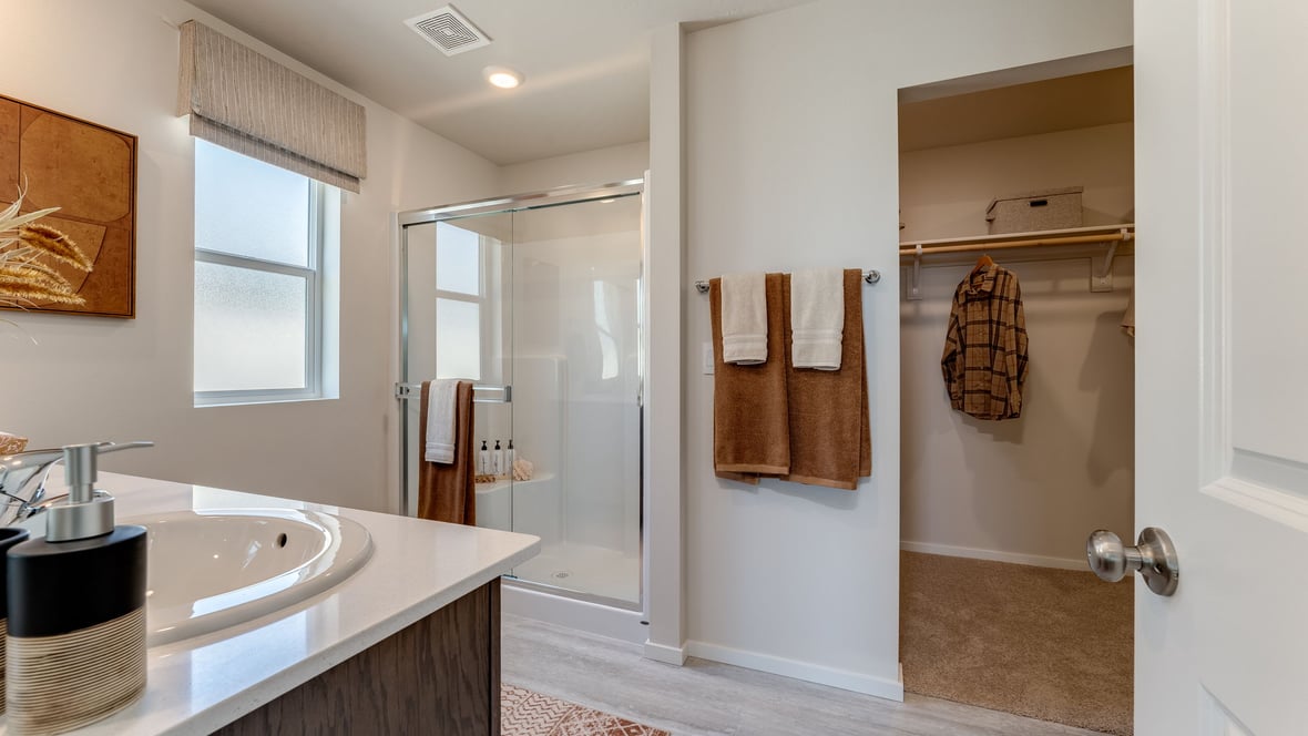 Primary bathroom with quartz counters and a walk-in shower