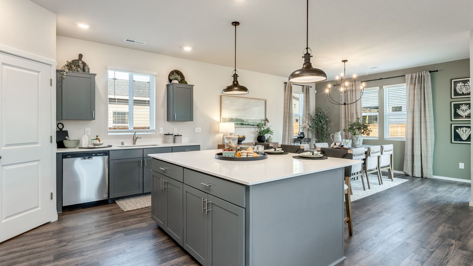 Kitchen with shaker cabinets, quartz counters, stainless steel appliances, pantry, and an island with a breakfast bar