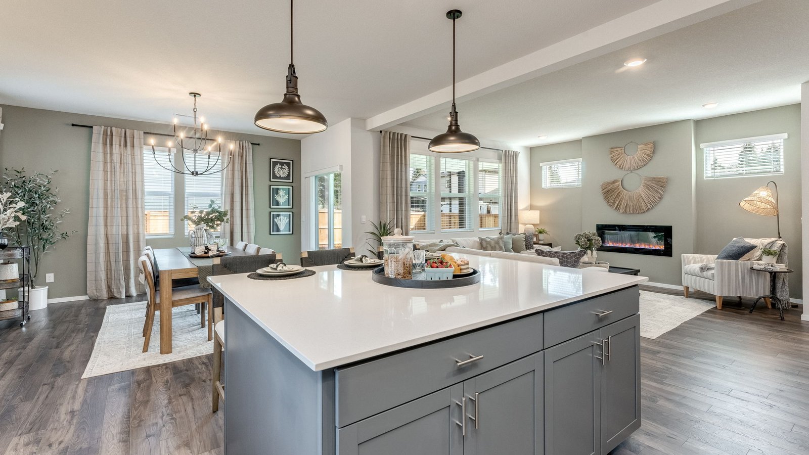 Kitchen with shaker cabinets, quartz counters, stainless steel appliances, pantry, and an island with a breakfast bar