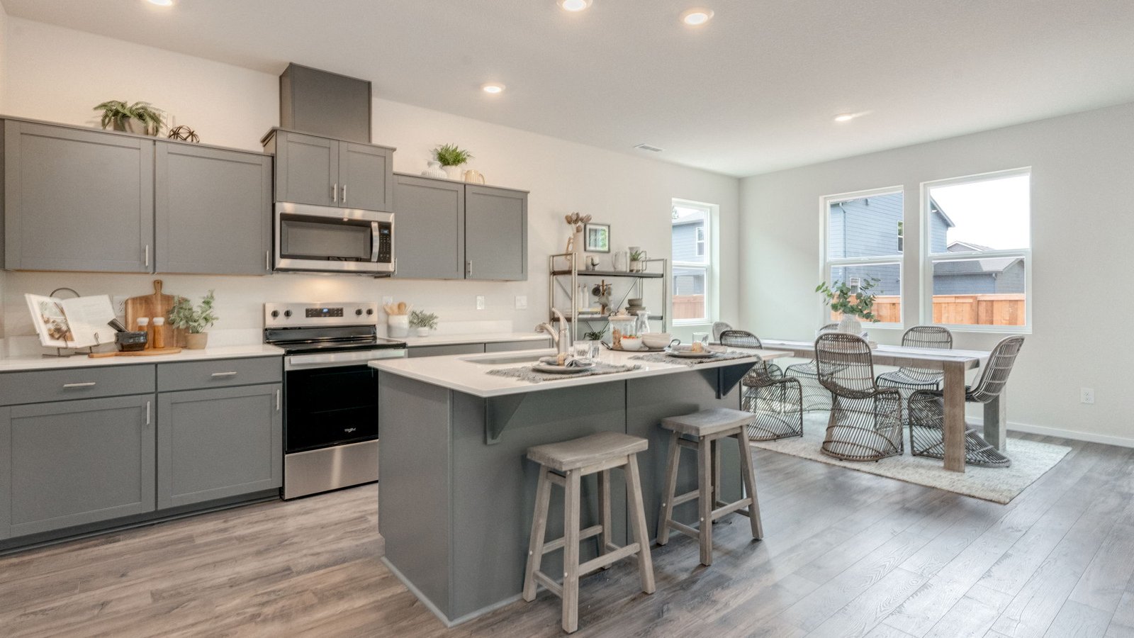 Kitchen with shaker cabinets, quartz counters, stainless steel appliances, pantry, and an island with a breakfast bar