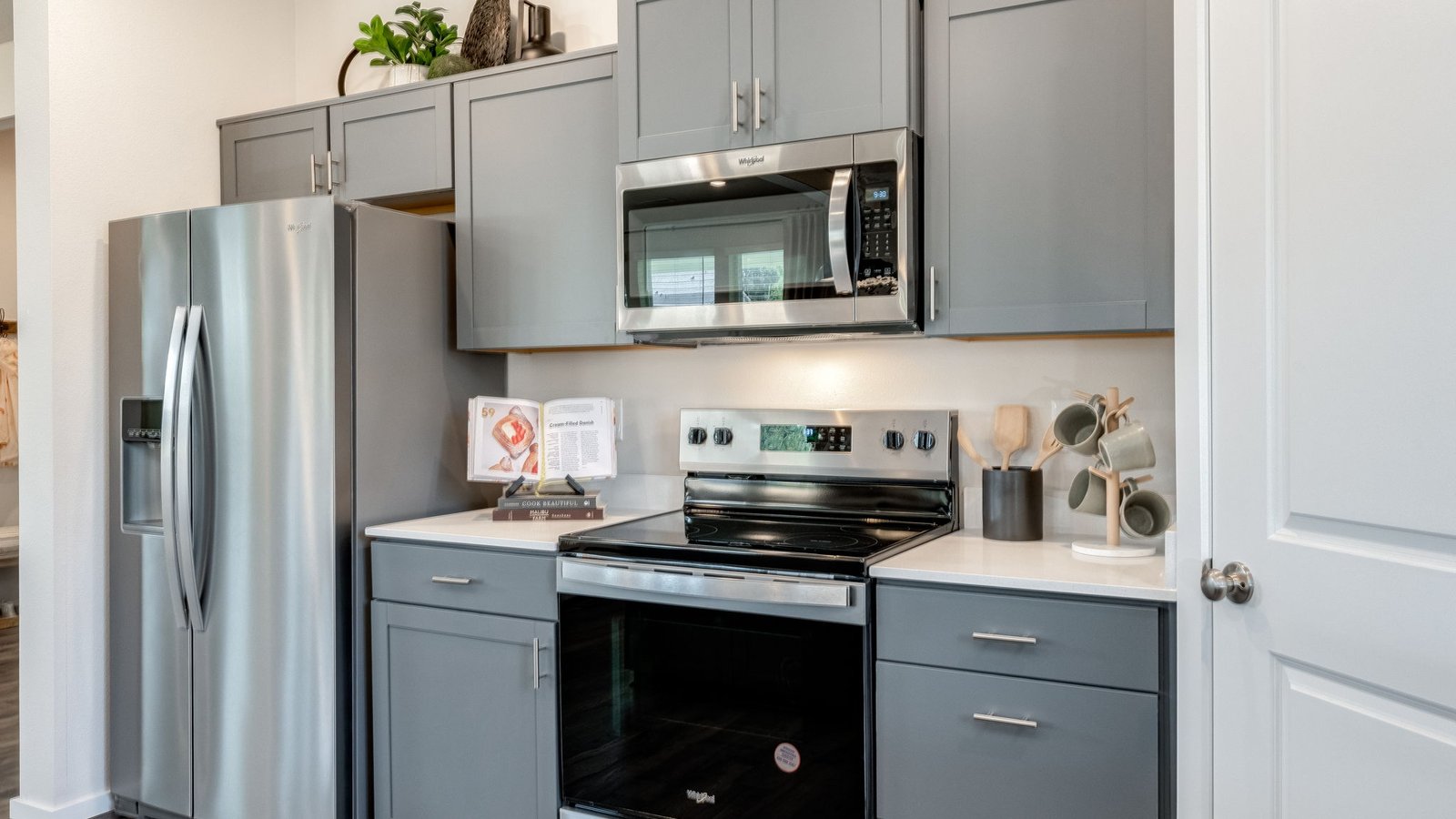 Kitchen with shaker cabinets, quartz counters, stainless steel appliances, pantry, and an island with a breakfast bar