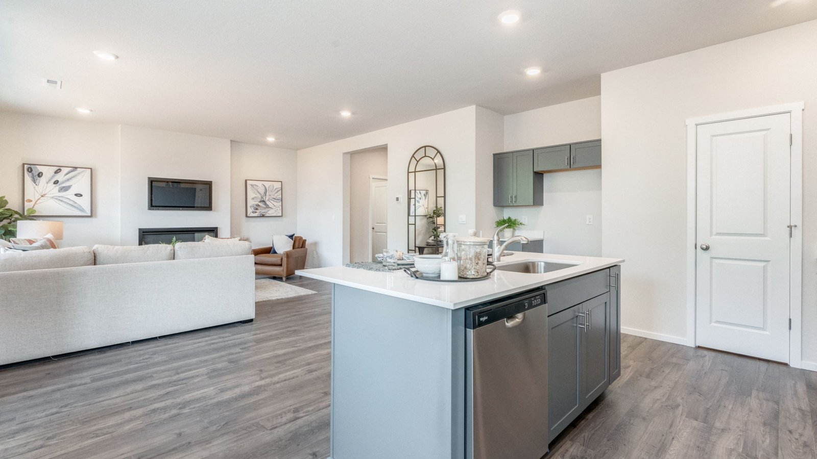 Kitchen with shaker cabinets, quartz counters, stainless steel appliances, pantry, and an island with a breakfast bar