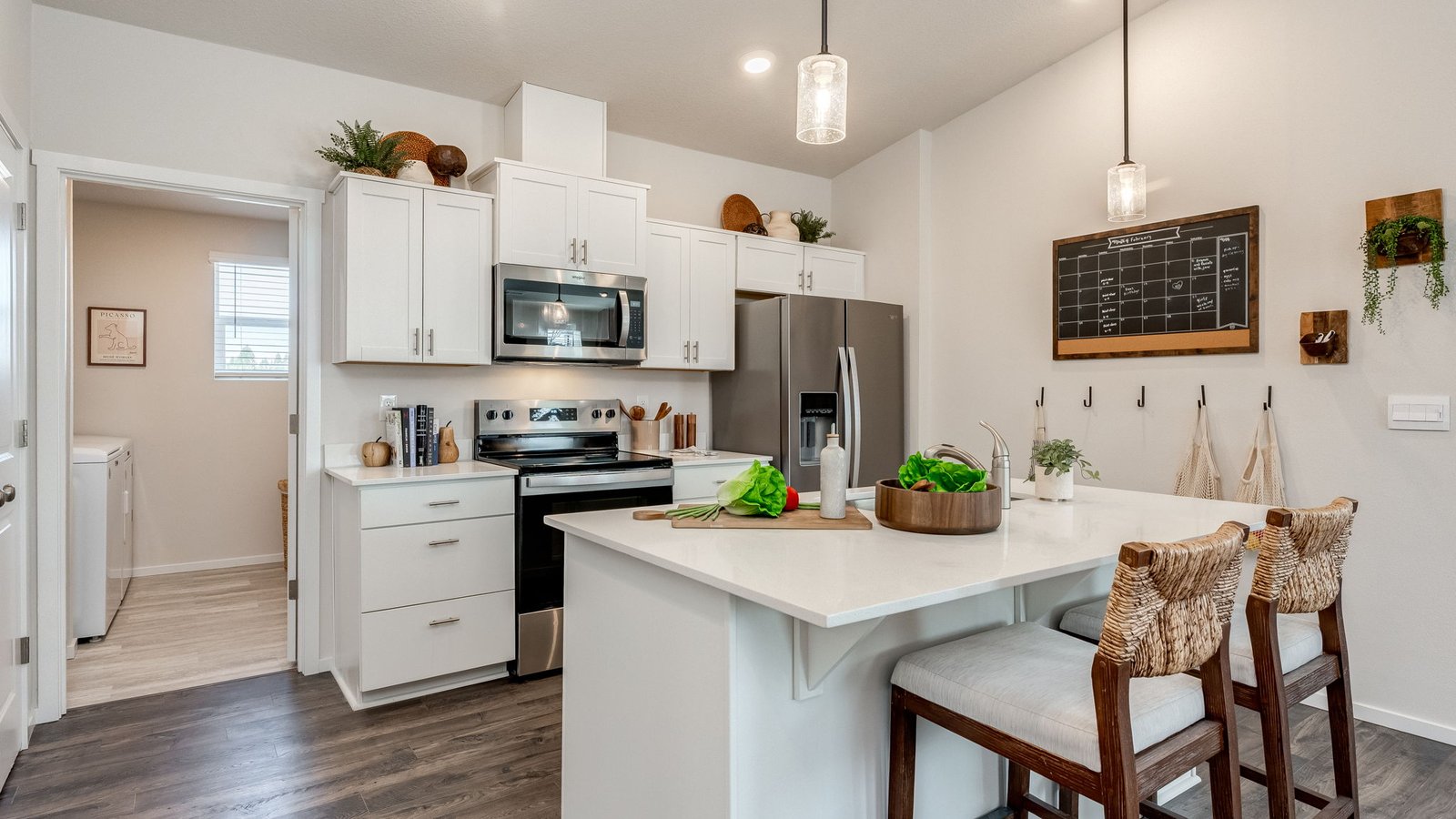 Kitchen with shaker cabinets, quartz counters, stainless steel appliances, pantry, and an island with a breakfast bar