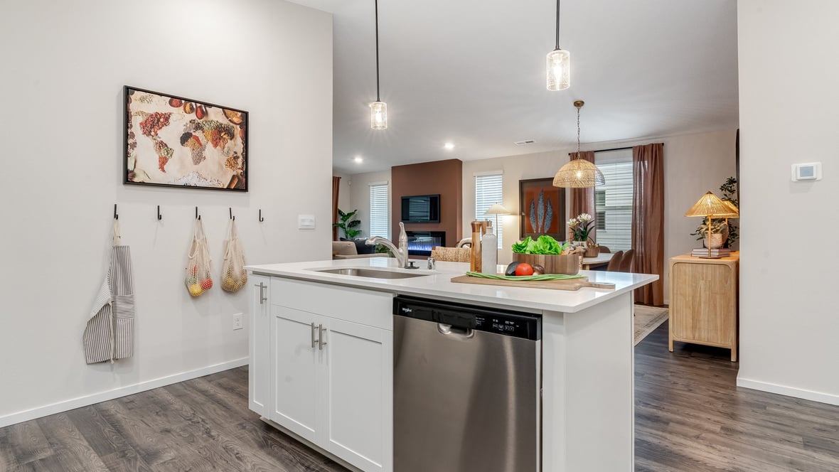 Kitchen with shaker cabinets, quartz counters, stainless steel appliances, pantry, and an island with a breakfast bar