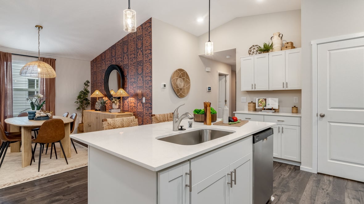 Kitchen with shaker cabinets, quartz counters, stainless steel appliances, pantry, and an island with a breakfast bar