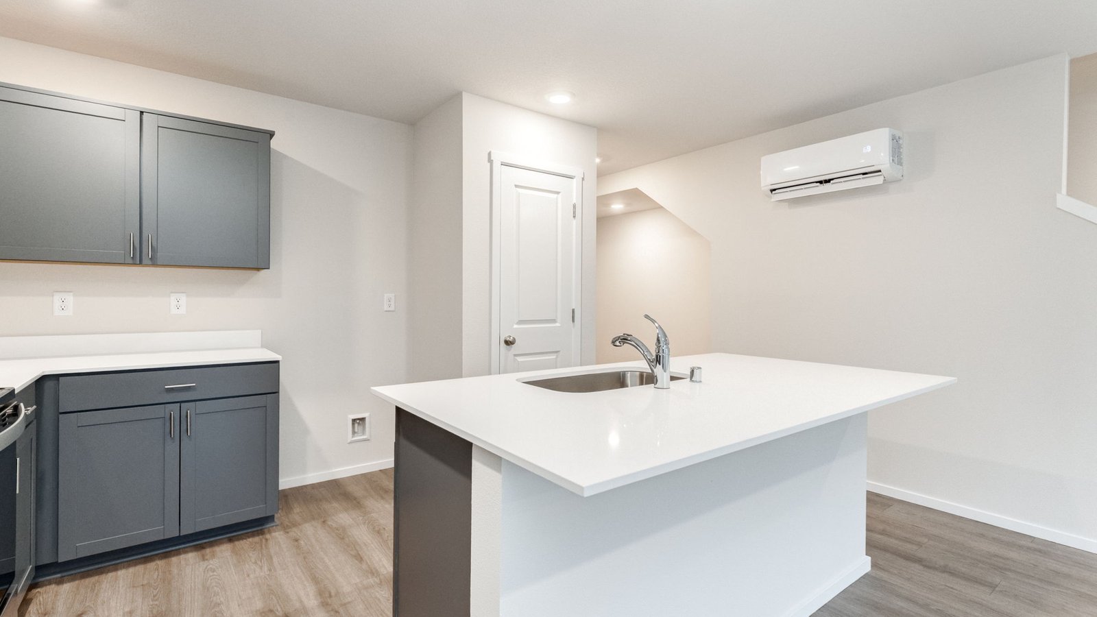 Kitchen with shaker cabinets, quartz counters, stainless steel appliances, pantry, and an island with a breakfast bar