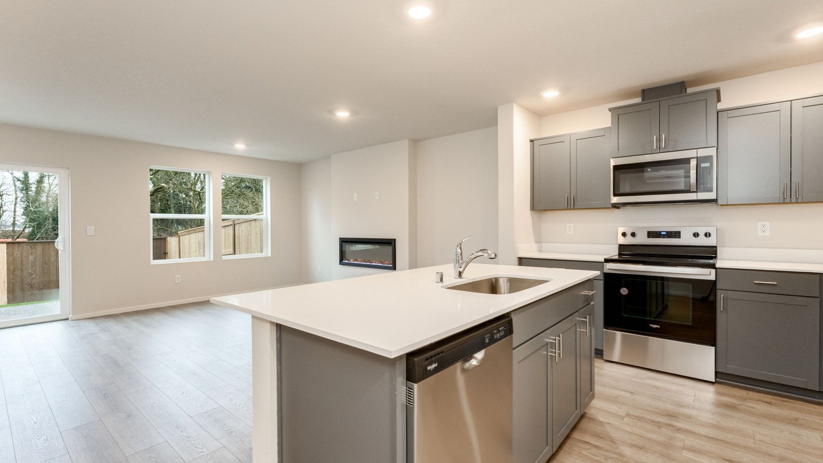 Kitchen with shaker cabinets, quartz counters, stainless steel appliances, pantry, and an island with a breakfast bar