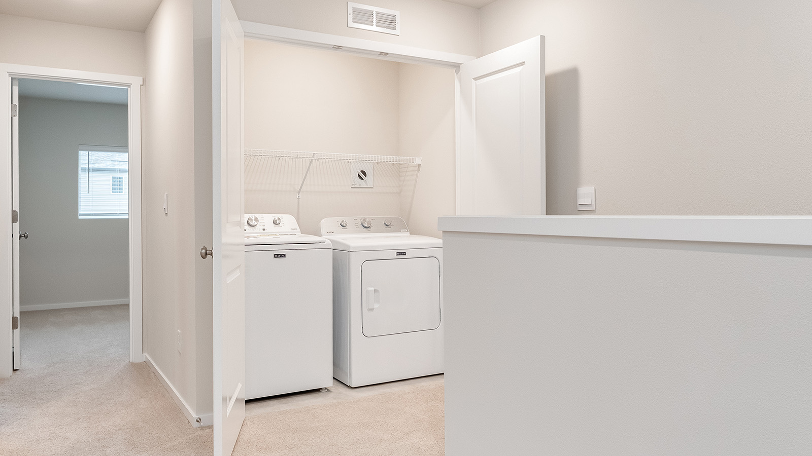 Laundry closet with wire shelves and washer and dryer hookups