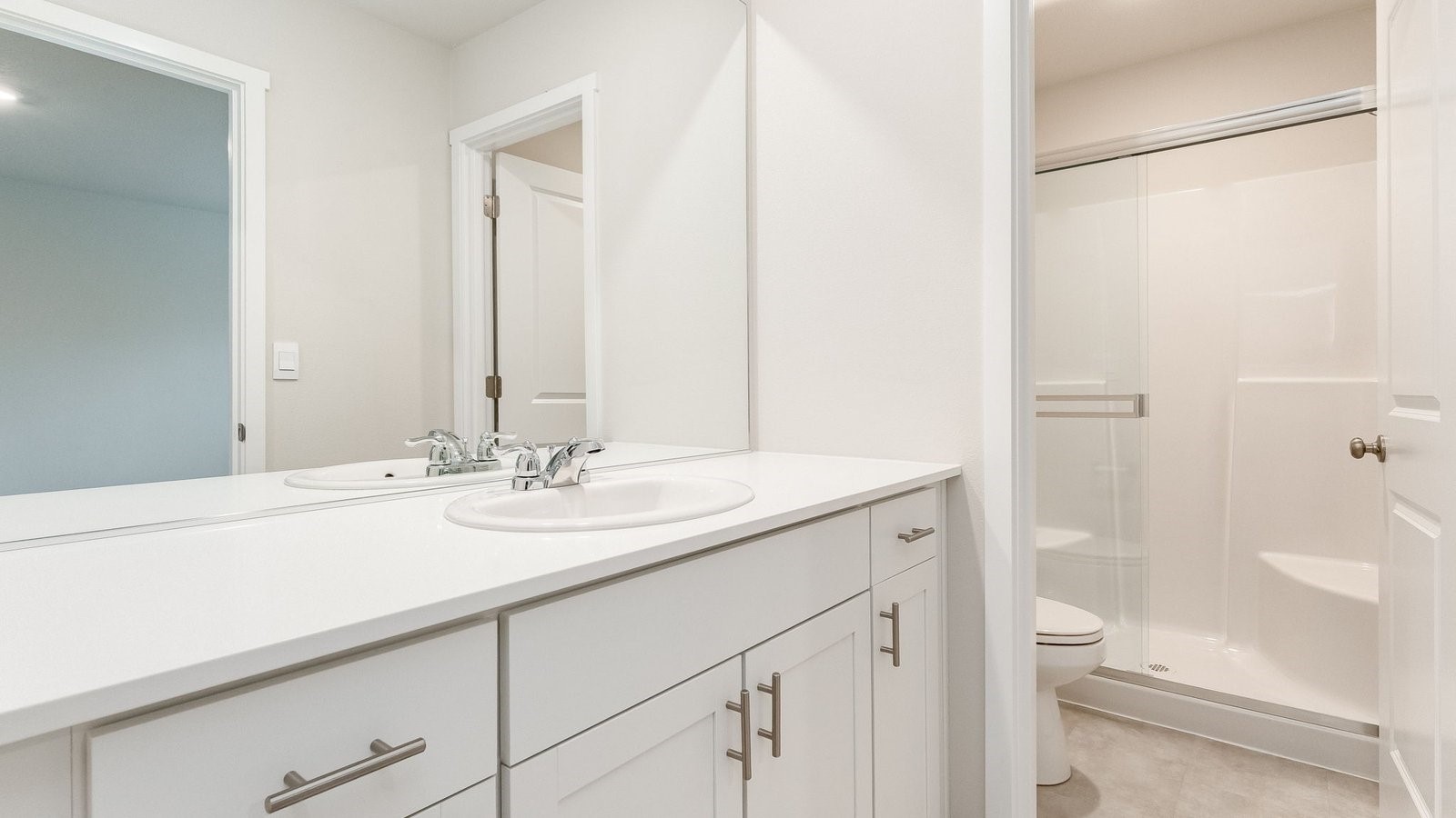 Primary bathroom with quartz counters and a walk-in shower
