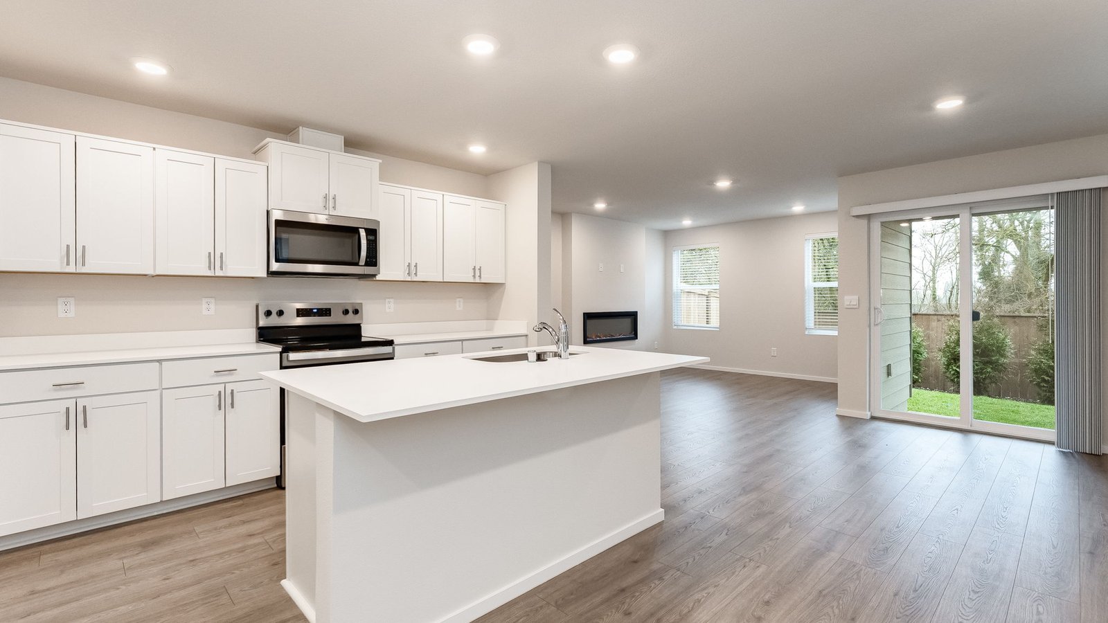 Kitchen with shaker cabinets, quartz counters, stainless steel appliances, pantry, and an island with a breakfast bar