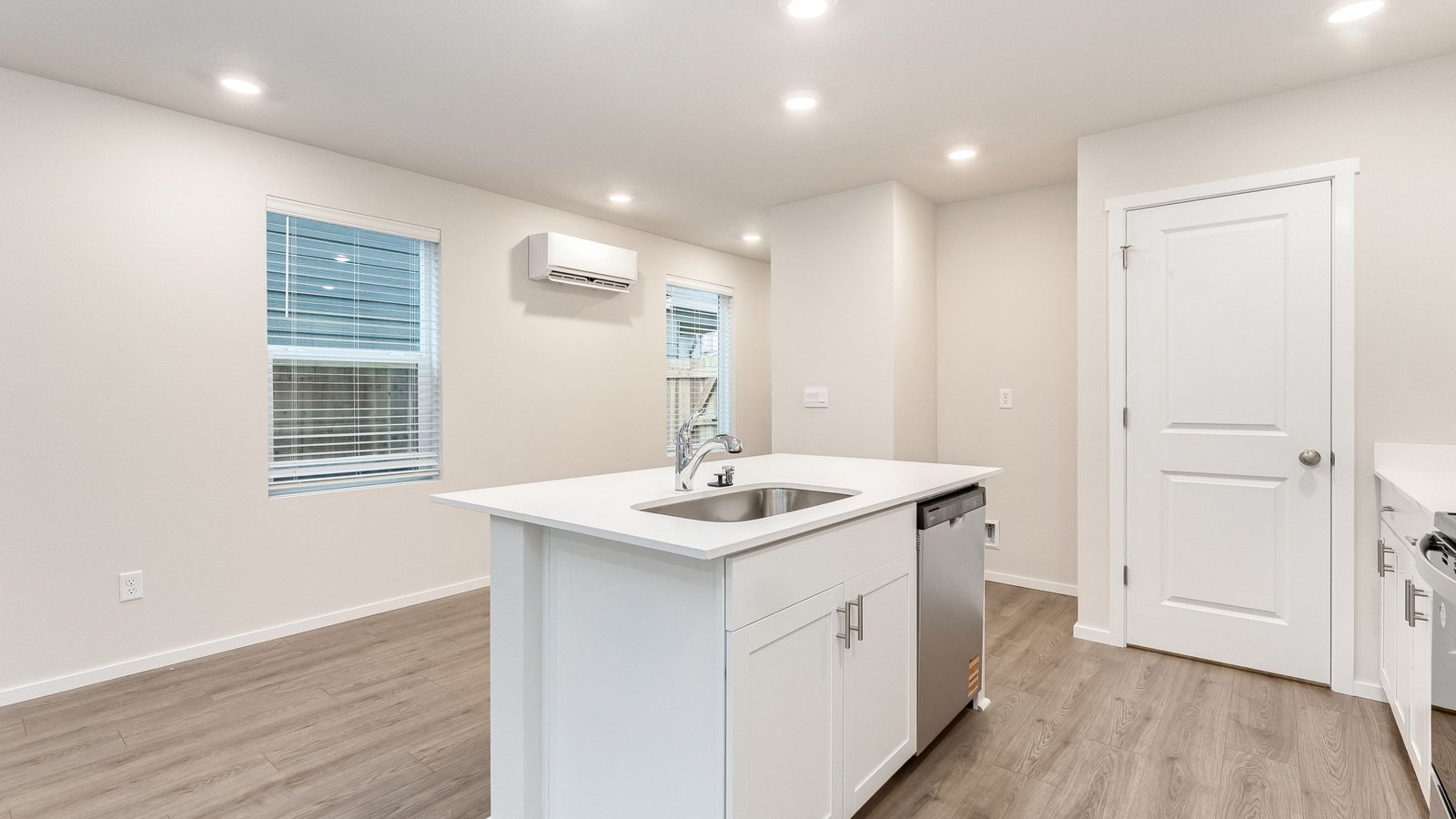 Kitchen with shaker cabinets, quartz counters, stainless steel appliances, pantry, and an island with a breakfast bar