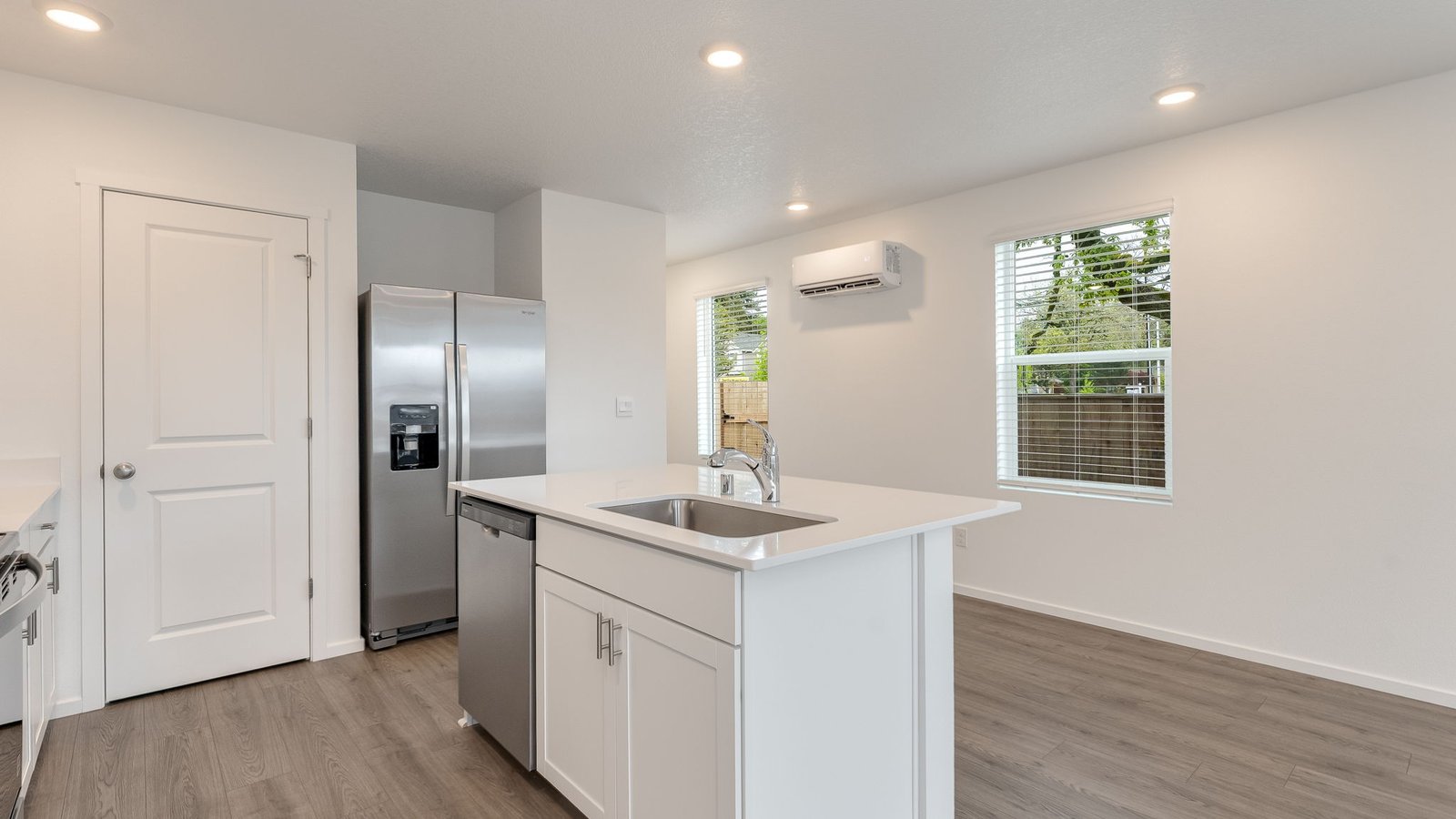 Kitchen with shaker cabinets, quartz counters, stainless steel appliances, pantry, and an island with a breakfast bar