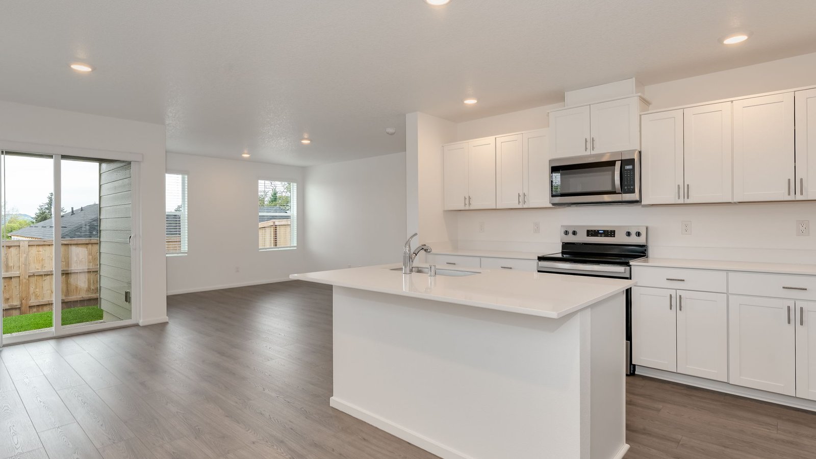 Kitchen with shaker cabinets, quartz counters, stainless steel appliances, pantry, and an island with a breakfast bar