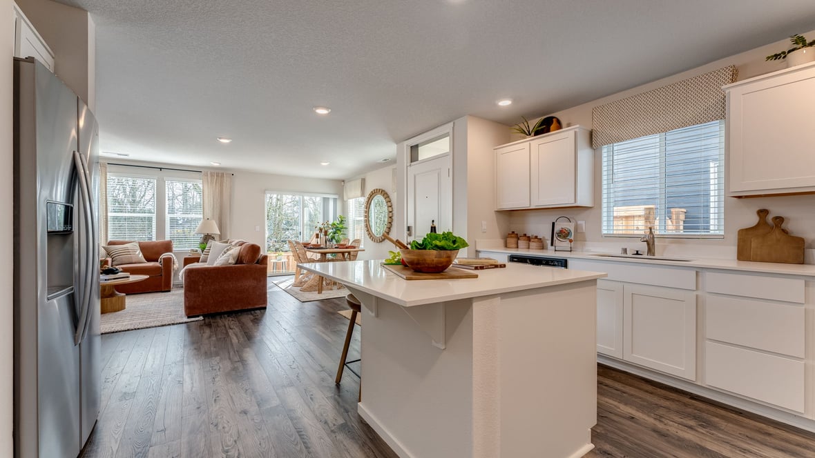 Kitchen with shaker cabinets, quartz counters, stainless steel appliances, pantry, and an island with a breakfast bar