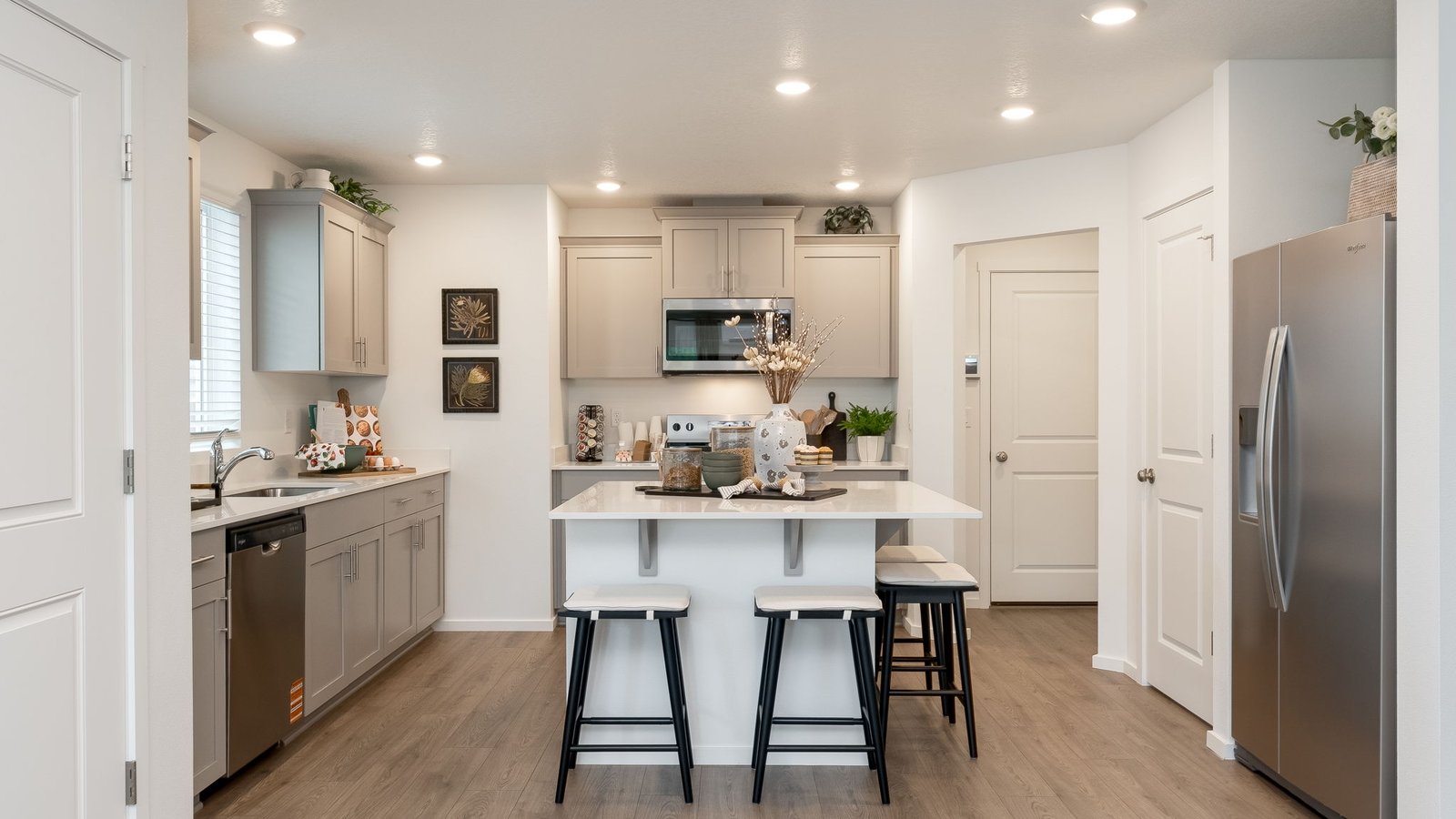 Kitchen with shaker cabinets, quartz counters, stainless steel appliances, pantry, and an island with a breakfast bar