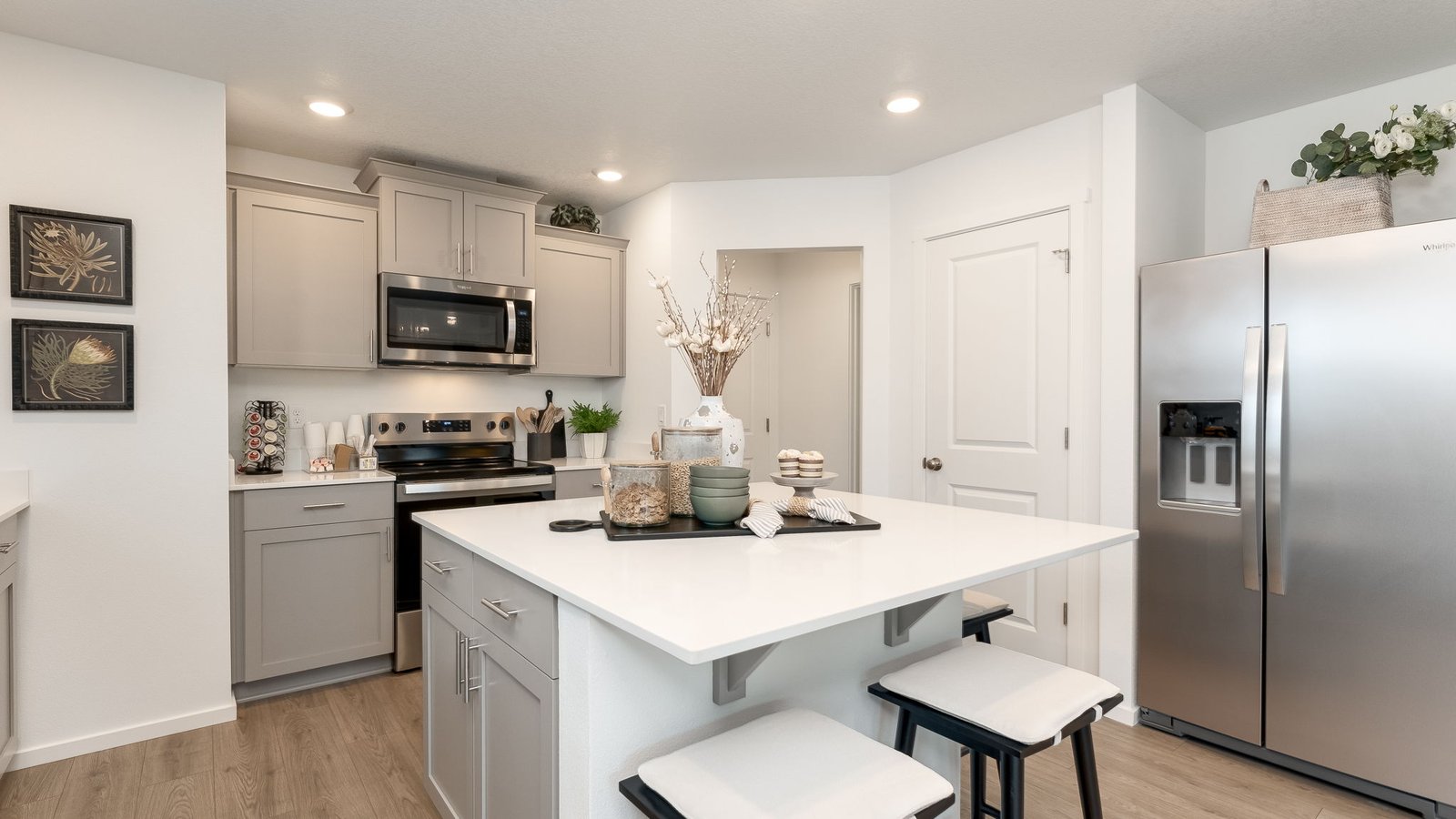 Kitchen with shaker cabinets, quartz counters, stainless steel appliances, pantry, and an island with a breakfast bar