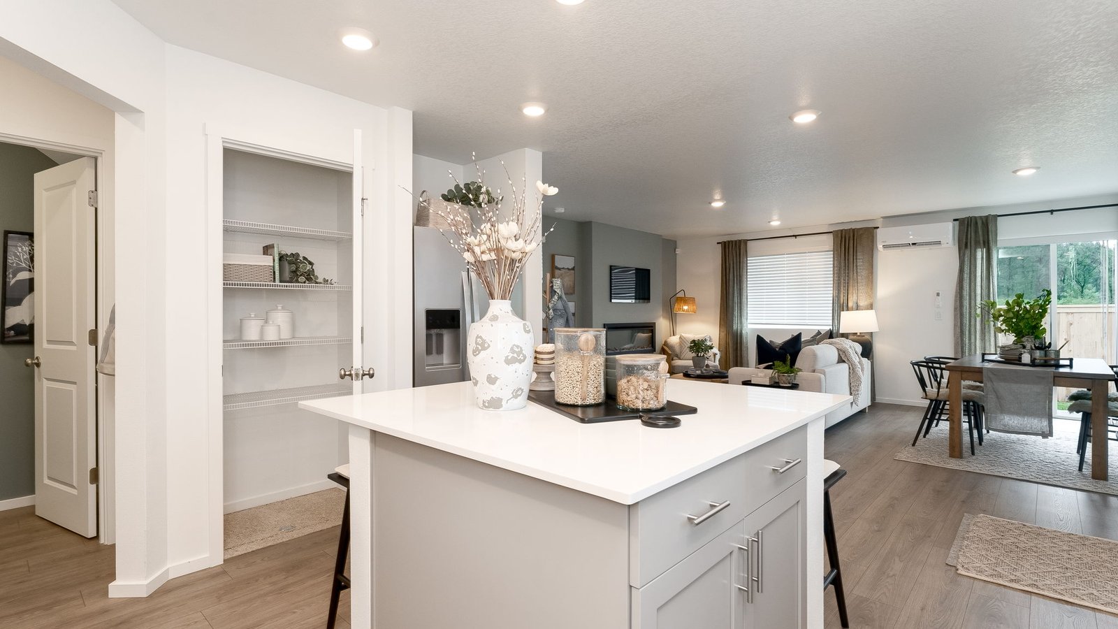 Kitchen with shaker cabinets, quartz counters, stainless steel appliances, pantry, and an island with a breakfast bar