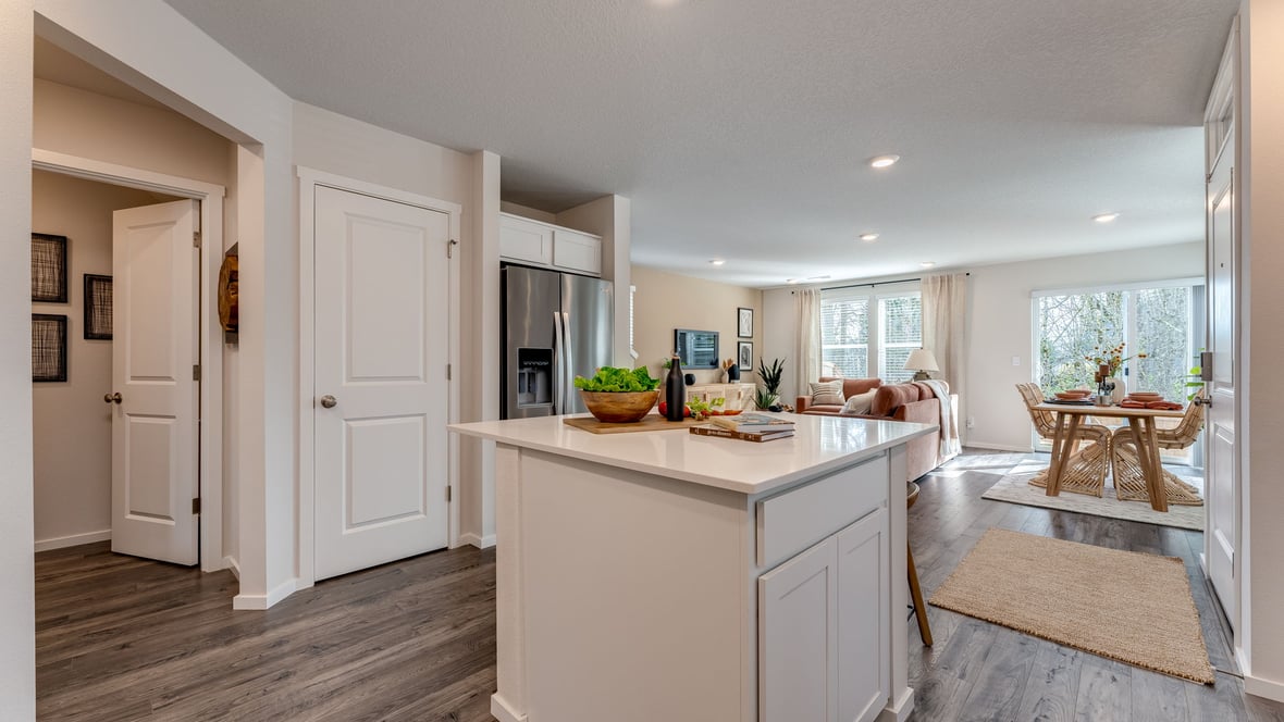 Kitchen with shaker cabinets, quartz counters, stainless steel appliances, pantry, and an island with a breakfast bar