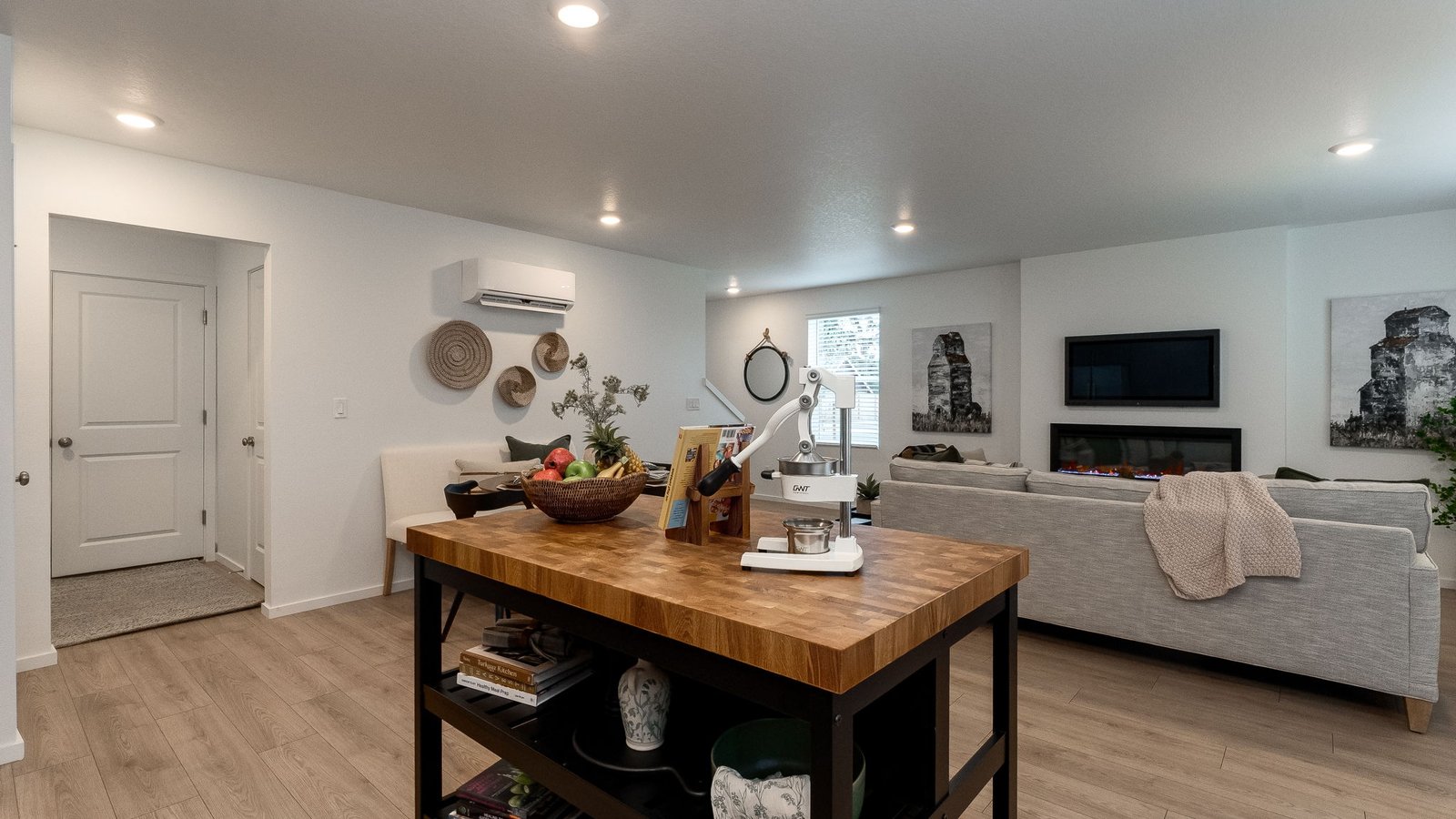 L-shaped kitchen with shaker cabinets, quartz counters, stainless steel appliances, and a pantry