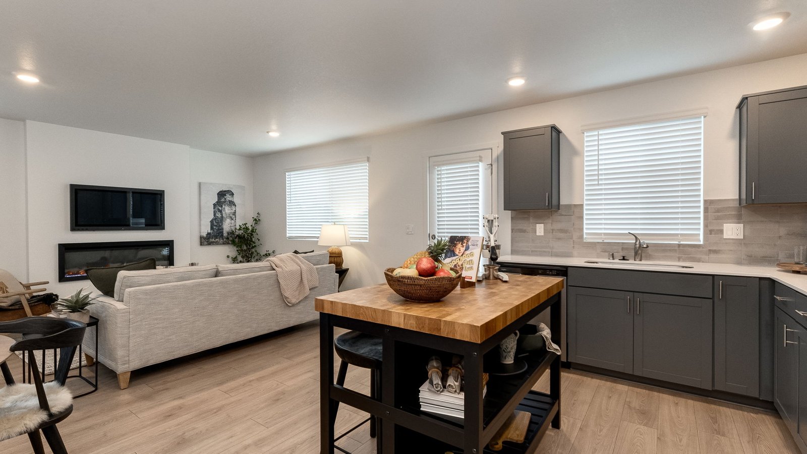 L-shaped kitchen with shaker cabinets, quartz counters, stainless steel appliances, and a pantry