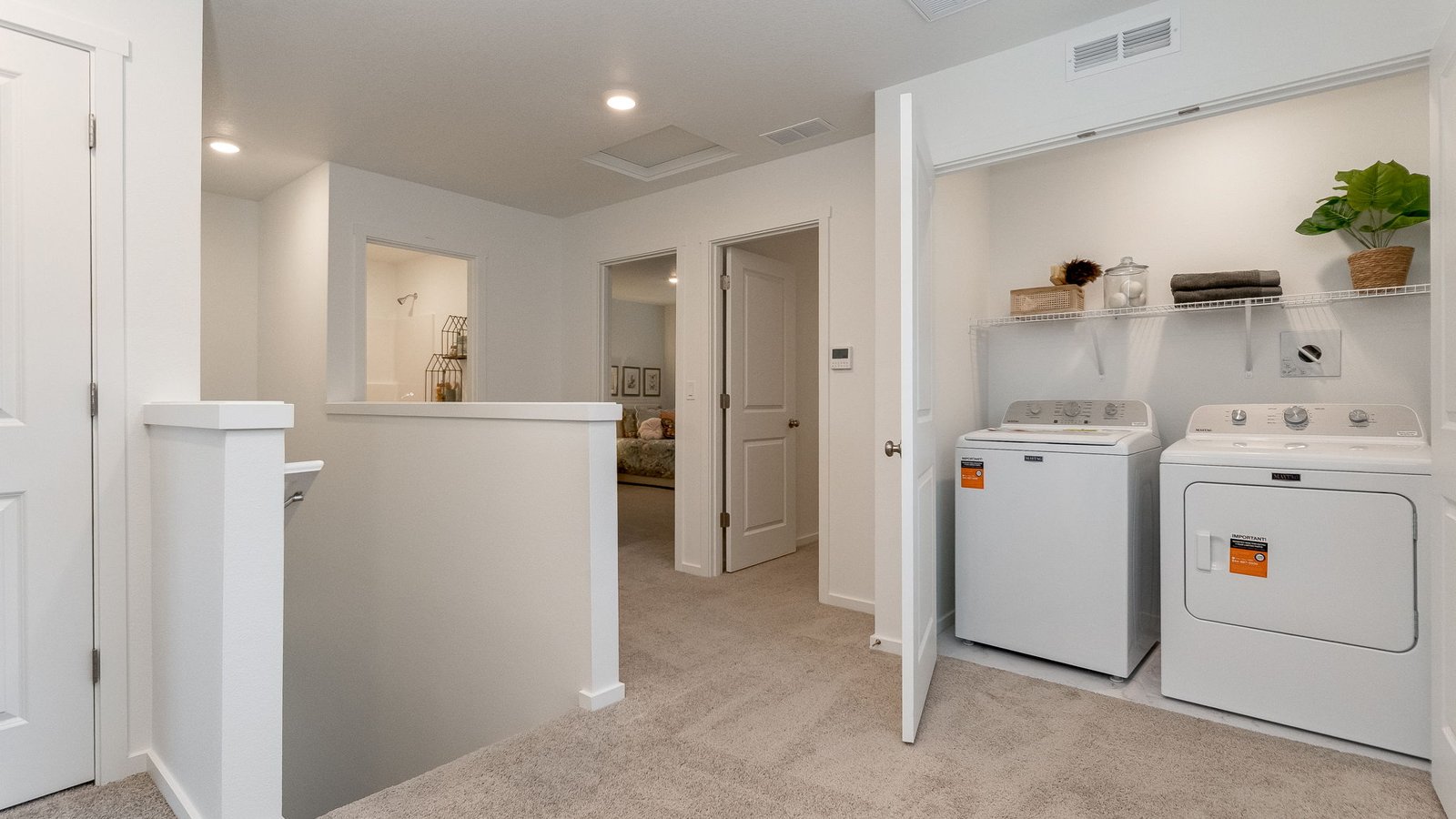 Laundry closet with wire shelves and washer and dryer hookups