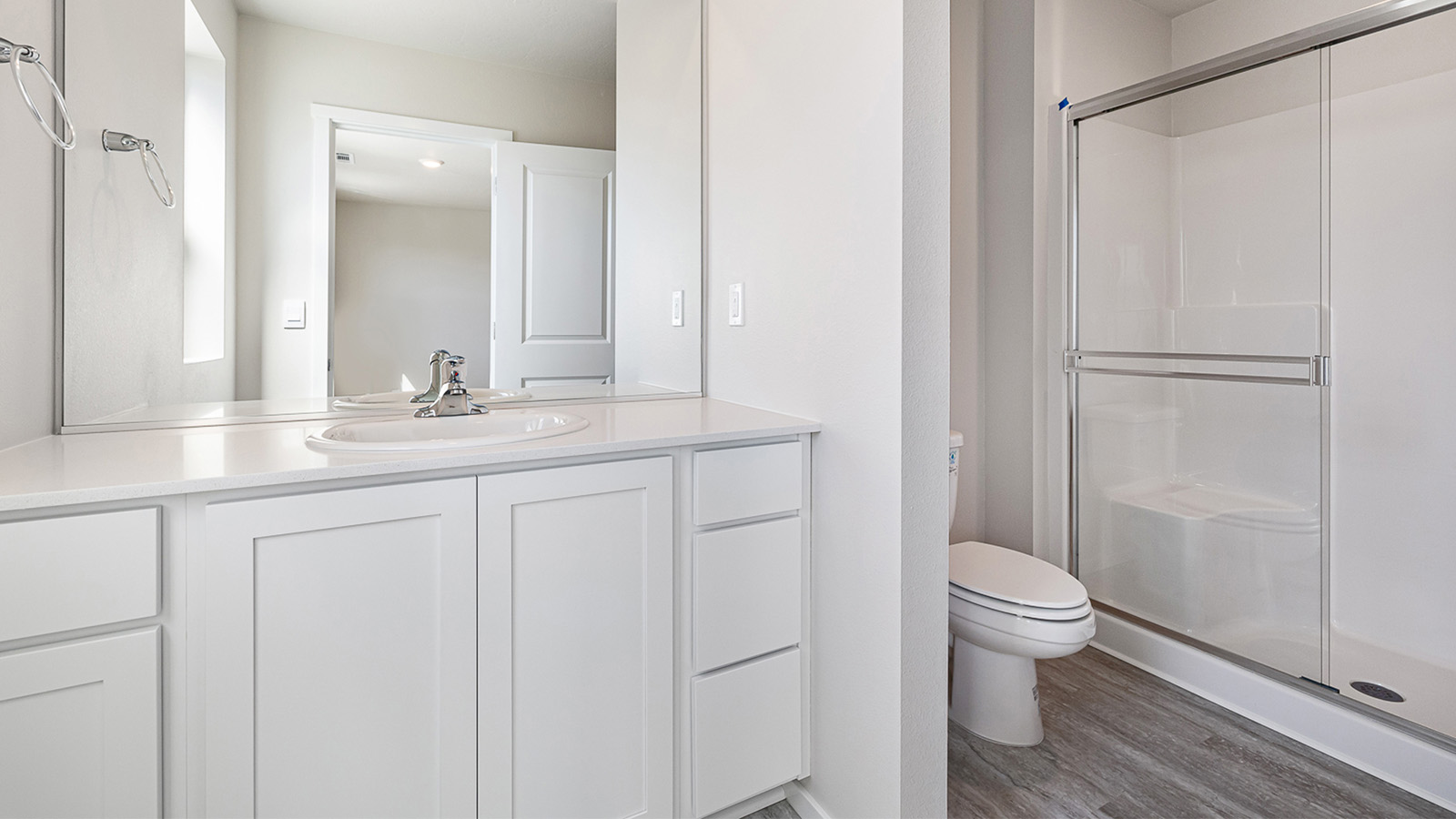 Primary bathroom with quartz counters and a walk-in shower