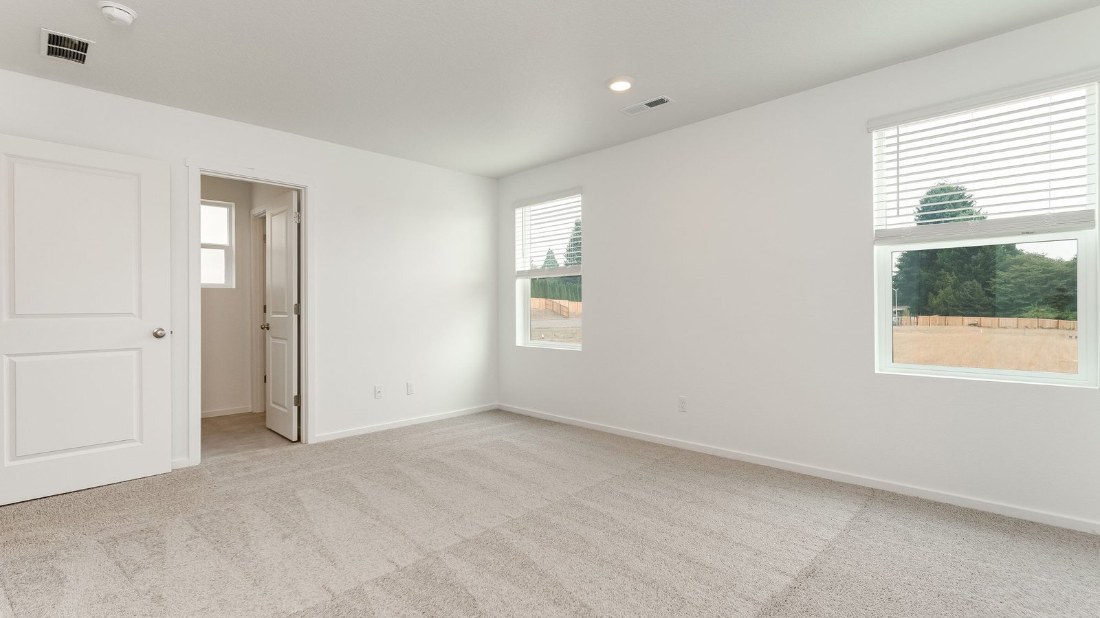 Primary bedroom with wall-to-wall carpet, a walk-in closet and an attached bathroom