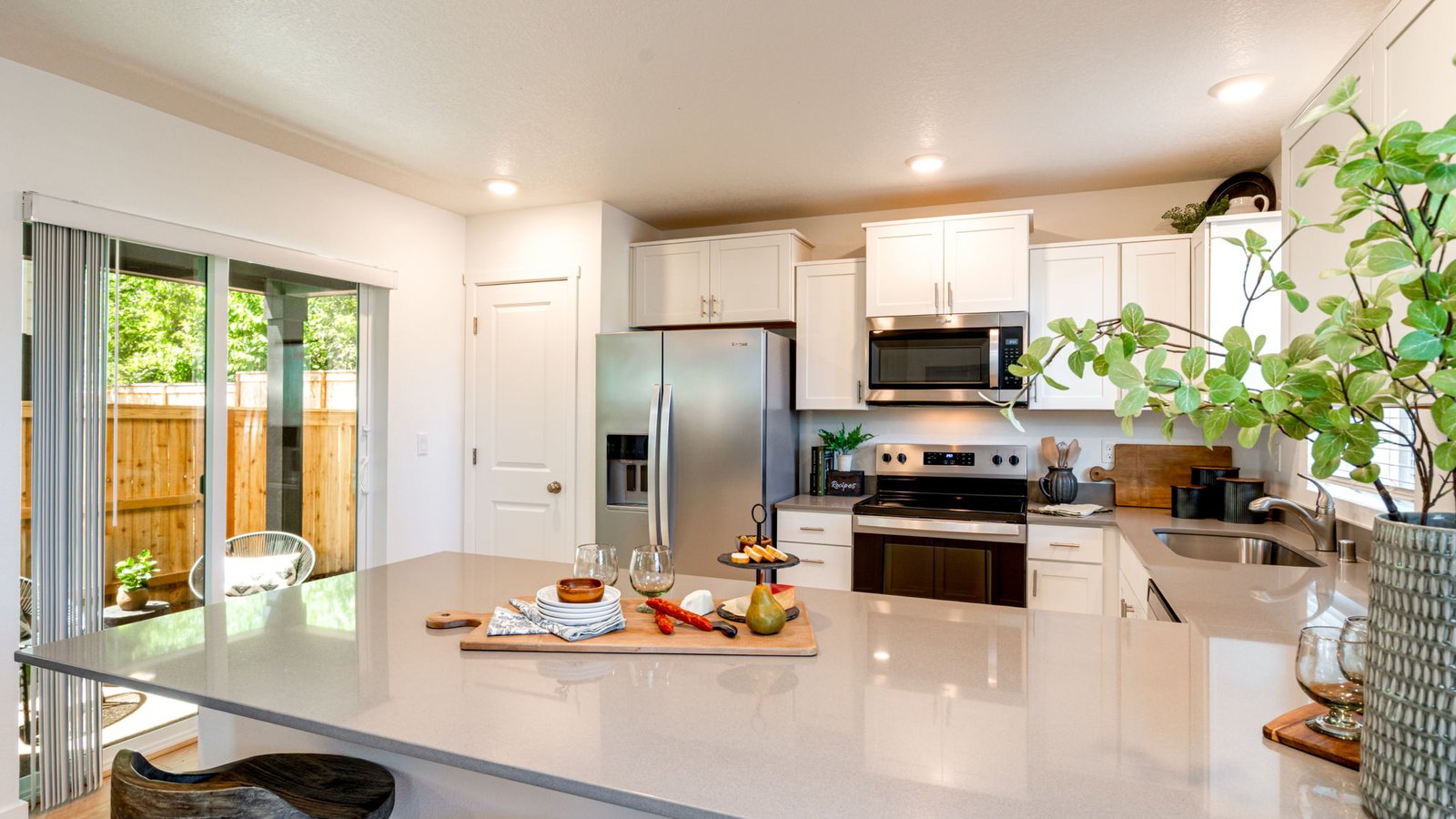 U-shaped kitchen with shaker cabinets, quartz counters, stainless steel appliances, pantry, and a breakfast bar
