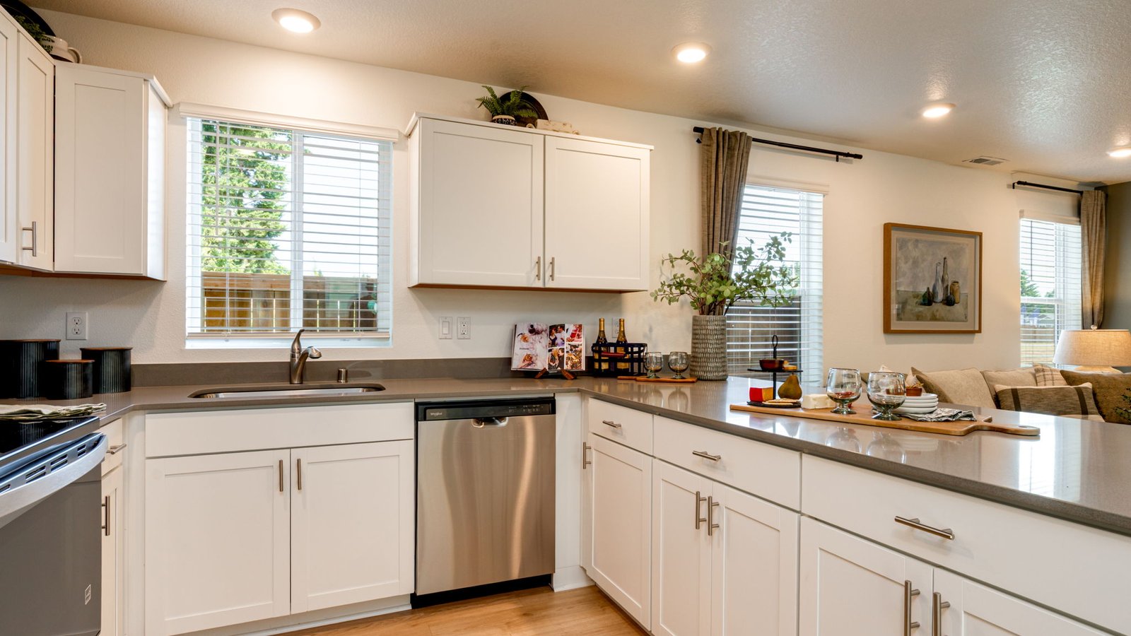 U-shaped kitchen with shaker cabinets, quartz counters, stainless steel appliances, pantry, and a breakfast bar