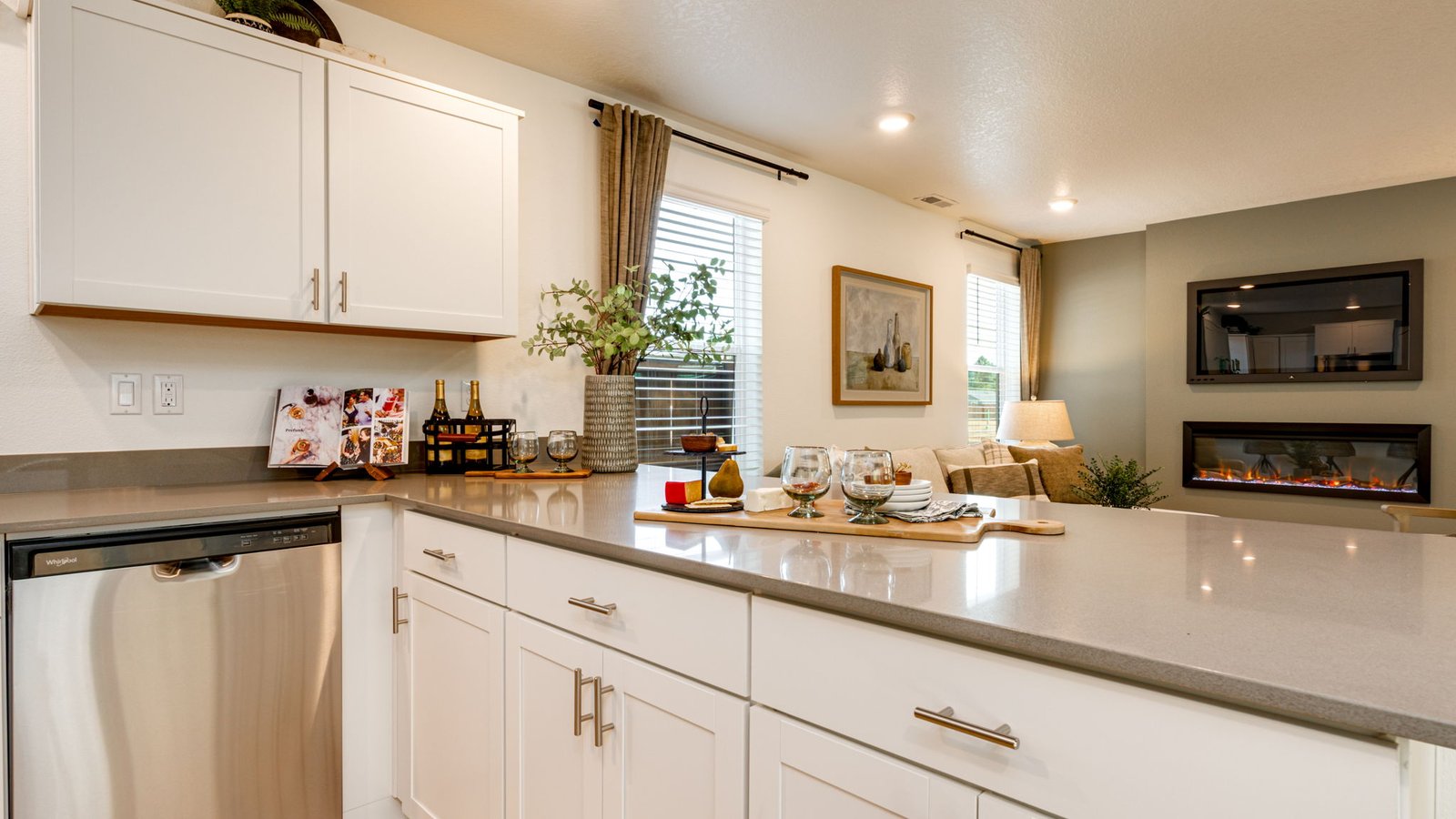 U-shaped kitchen with shaker cabinets, quartz counters, stainless steel appliances, pantry, and a breakfast bar