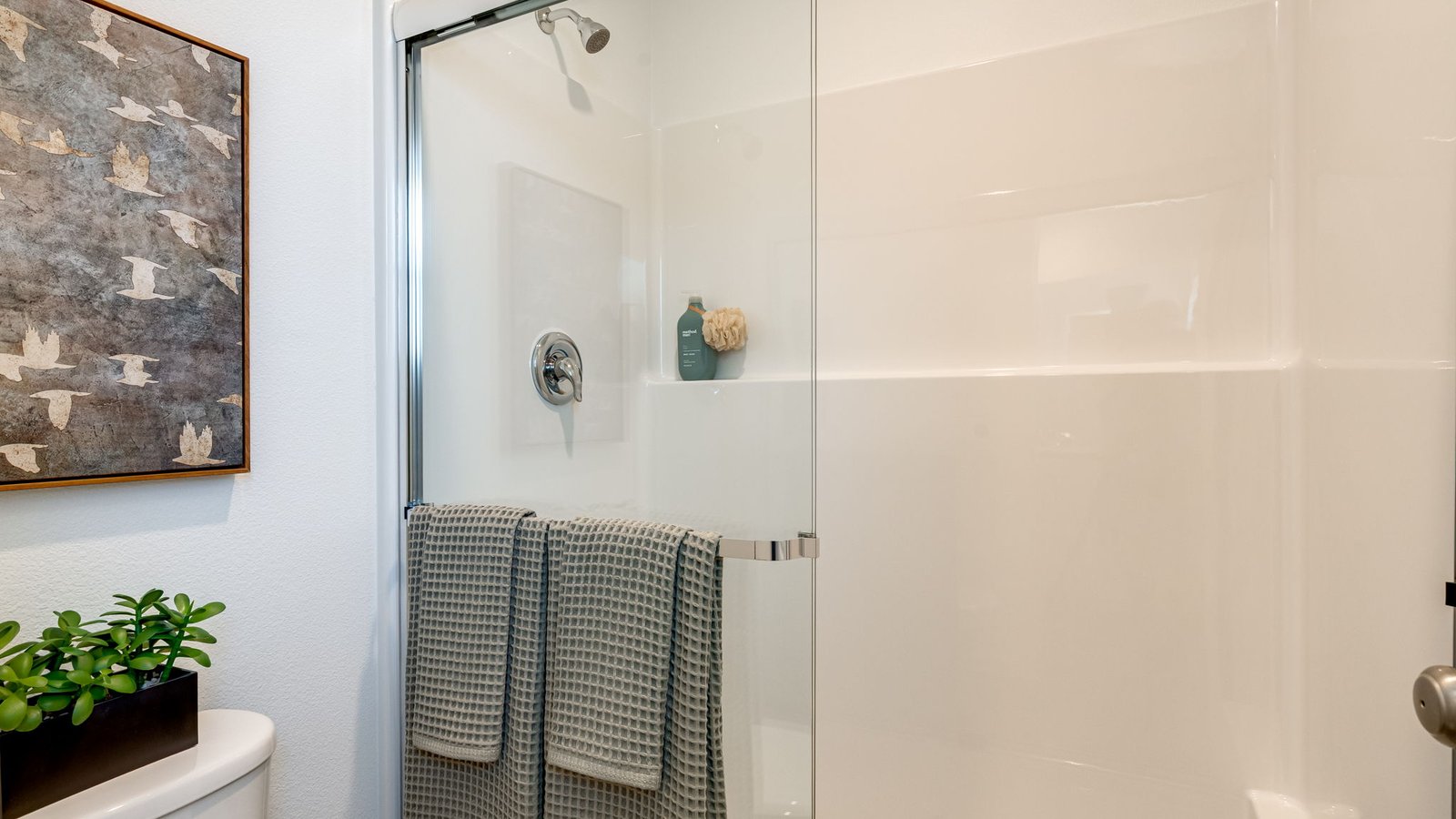 Primary bathroom with quartz counters and a walk-in shower