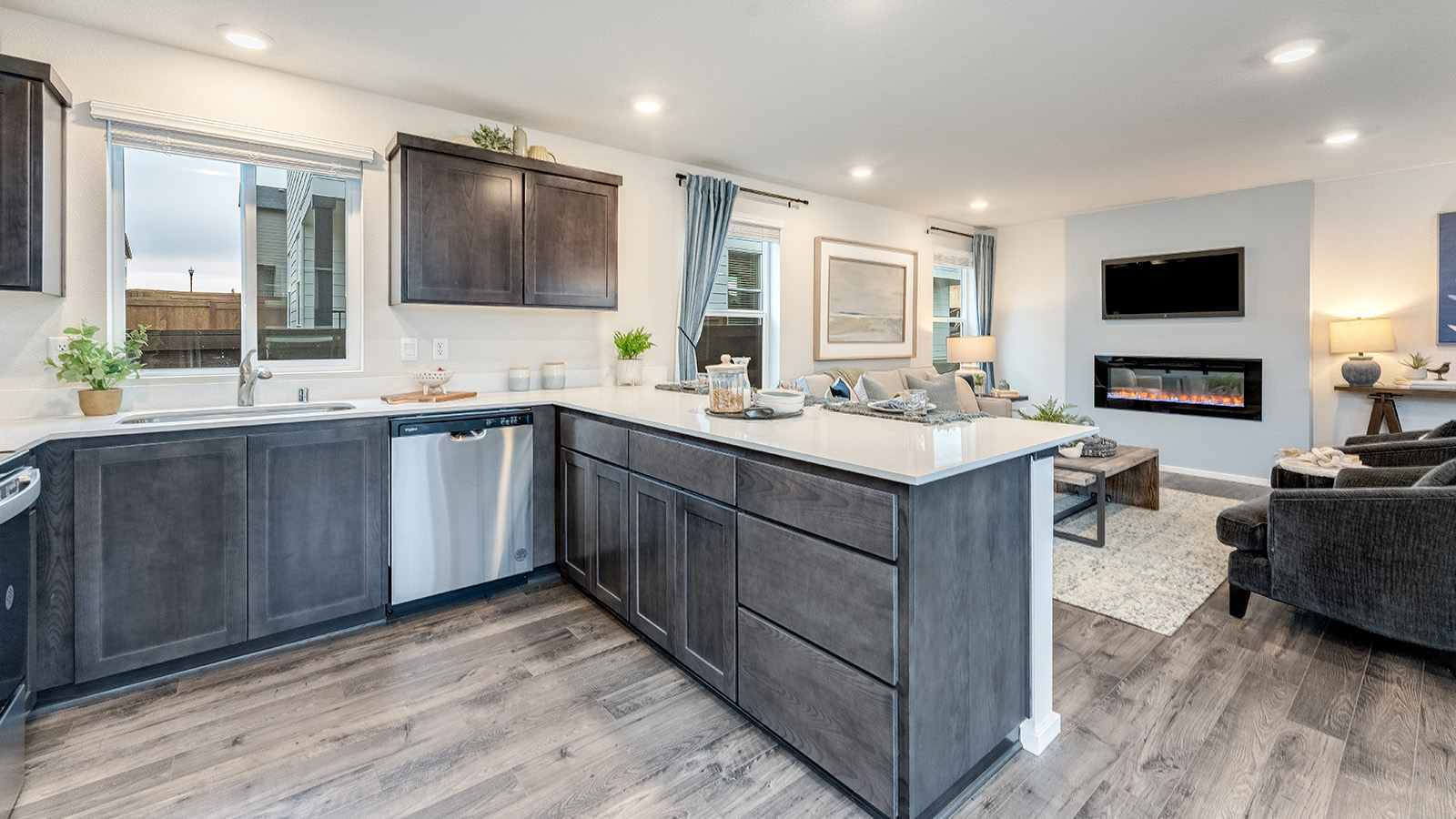 U-shaped kitchen with shaker cabinets, quartz counters, stainless steel appliances, pantry, and a breakfast bar