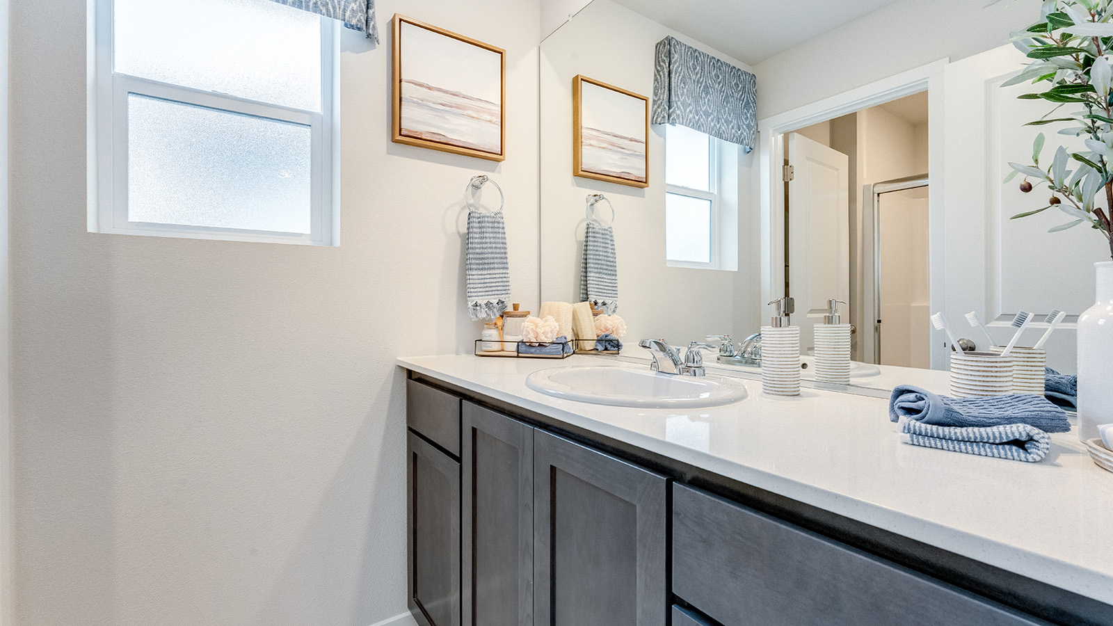 Primary bathroom with quartz counters and a walk-in shower