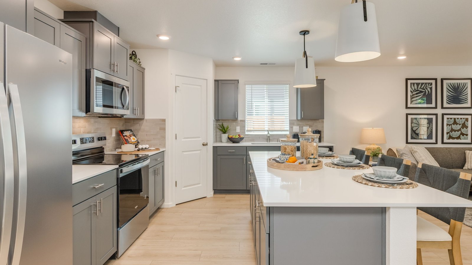 Kitchen with shaker cabinets, quartz counters, stainless steel appliances, pantry, and an island with a breakfast bar