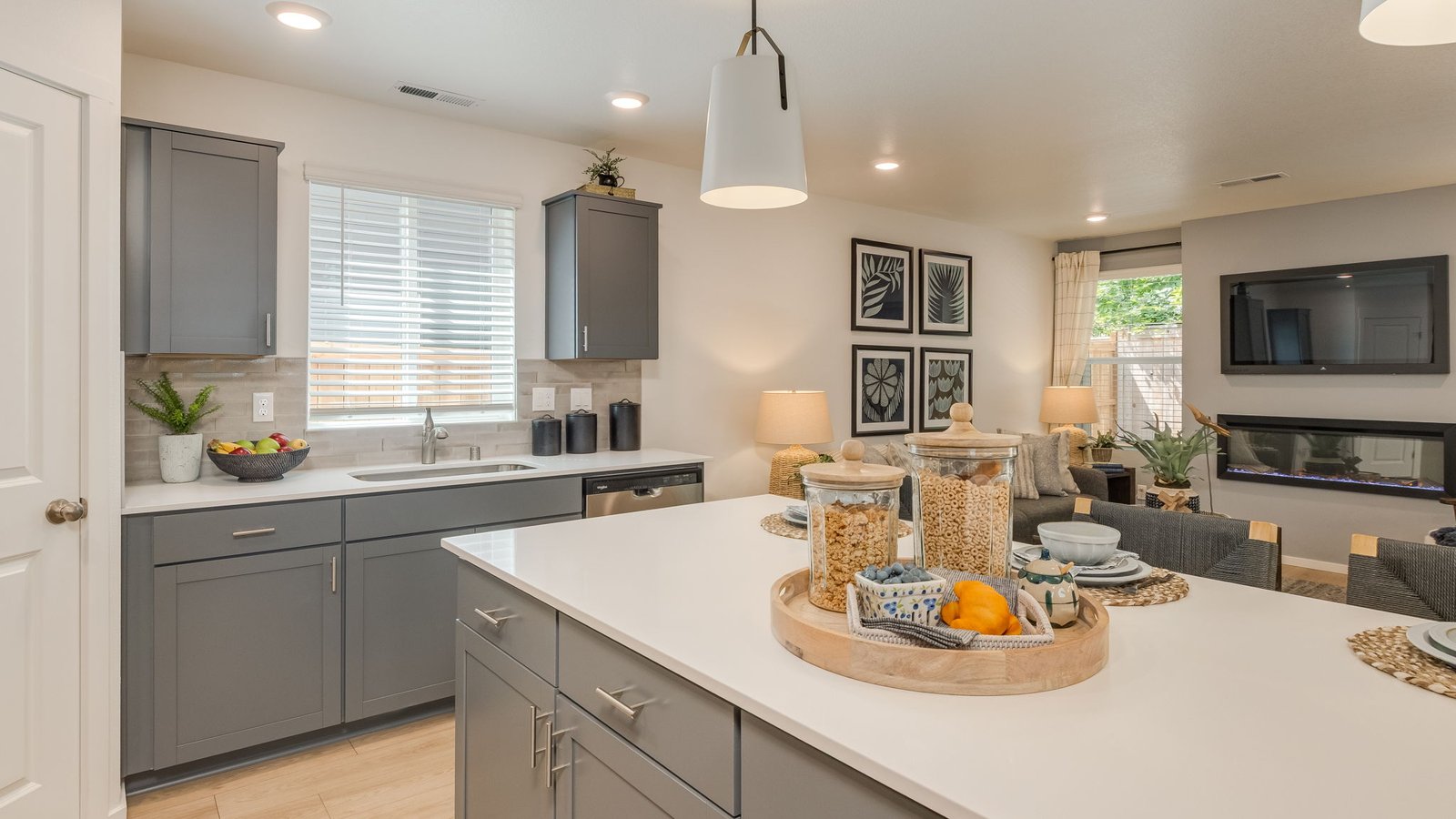 Kitchen with shaker cabinets, quartz counters, stainless steel appliances, pantry, and an island with a breakfast bar