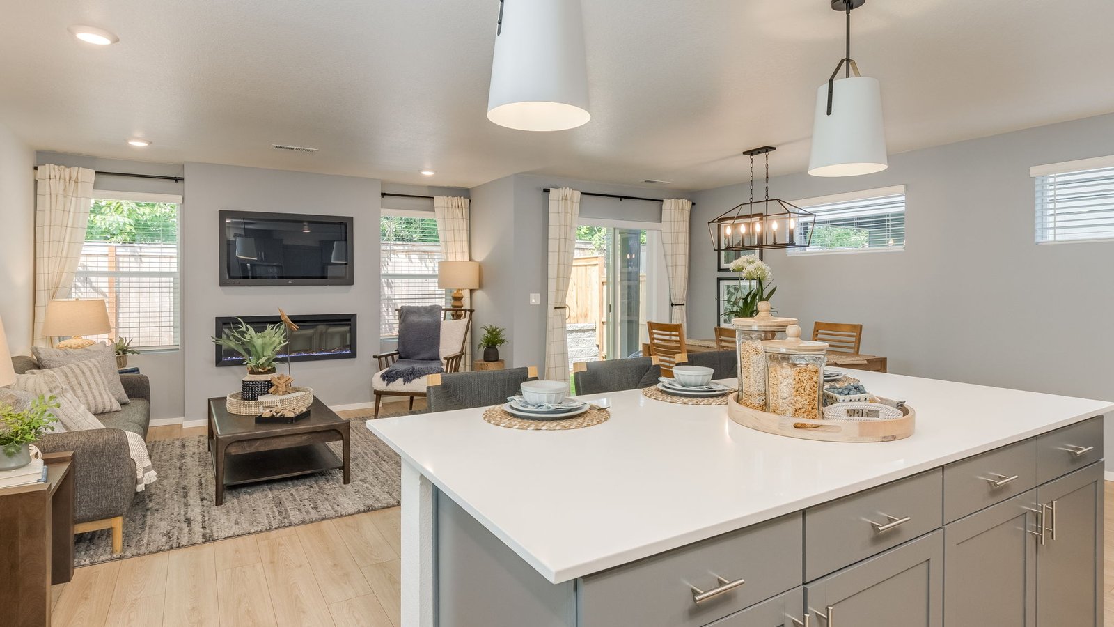 Kitchen with shaker cabinets, quartz counters, stainless steel appliances, pantry, and an island with a breakfast bar